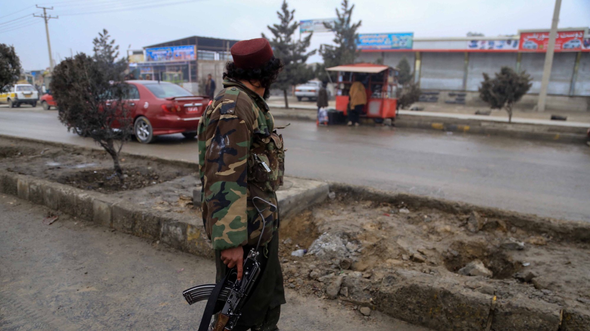 epa09689342 Taliban members inspect the scene of a bomb blast, in Kabul, Afghanistan, 16 January 2022. A bomb planted on a road divider was detonated when the vehicle was passing by an area in Bagrami district, killing at least two children and injuring four Taliban security personnel.  EPA/STRINGER