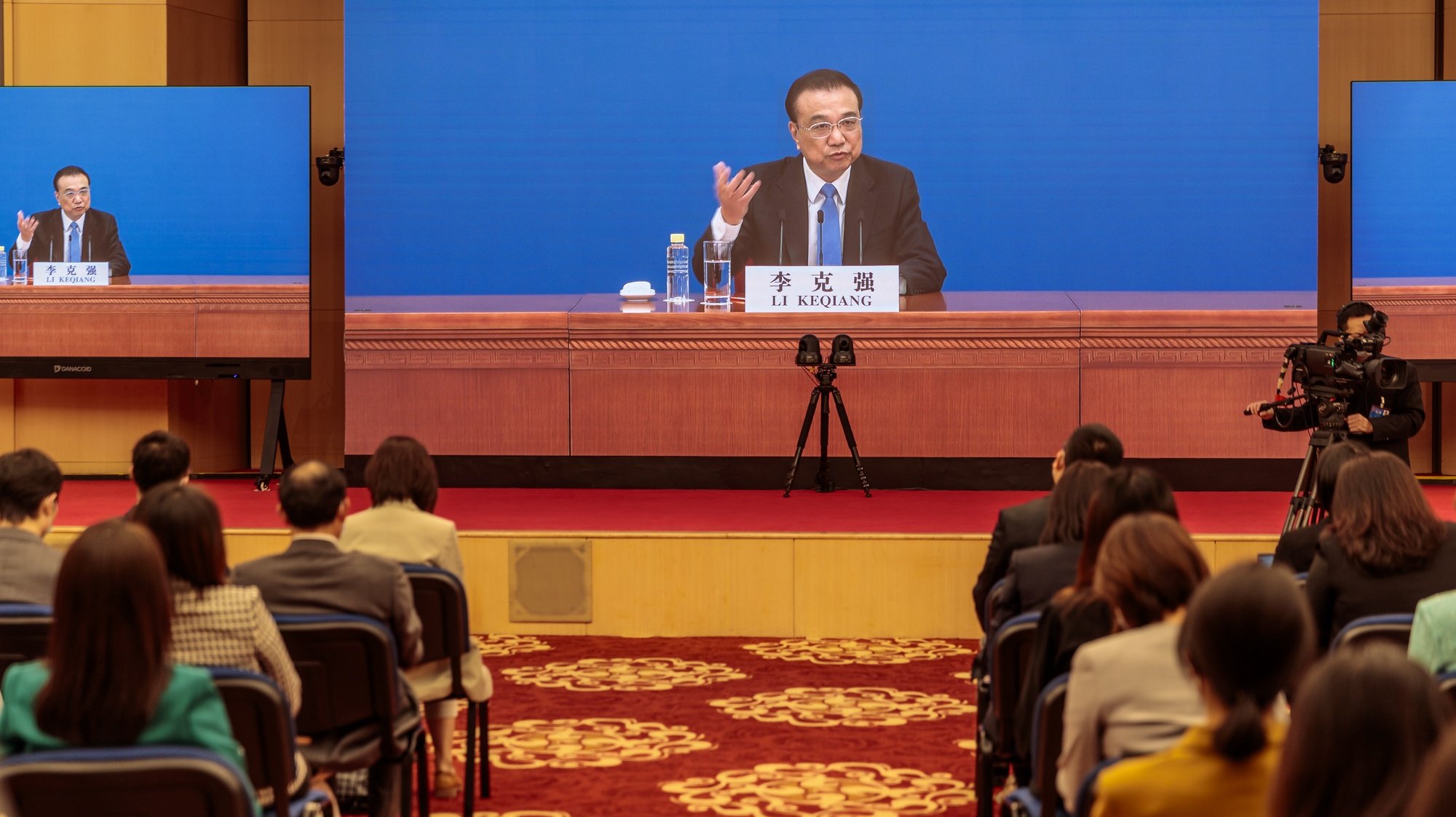epa09816523 Chinese Premier Li Keqiang is seen on screens as he speaks to reporters during an online press conference, in Beijing, China, 11 March 2022. China holds two major annual political meetings, The National People’s Congress (NPC) and the Chinese People&#039;s Political Consultative Conference (CPPCC) which run alongside and together known as &#039;Lianghui&#039; or &#039;Two Sessions&#039;.  EPA/ALEX PLAVEVSKI