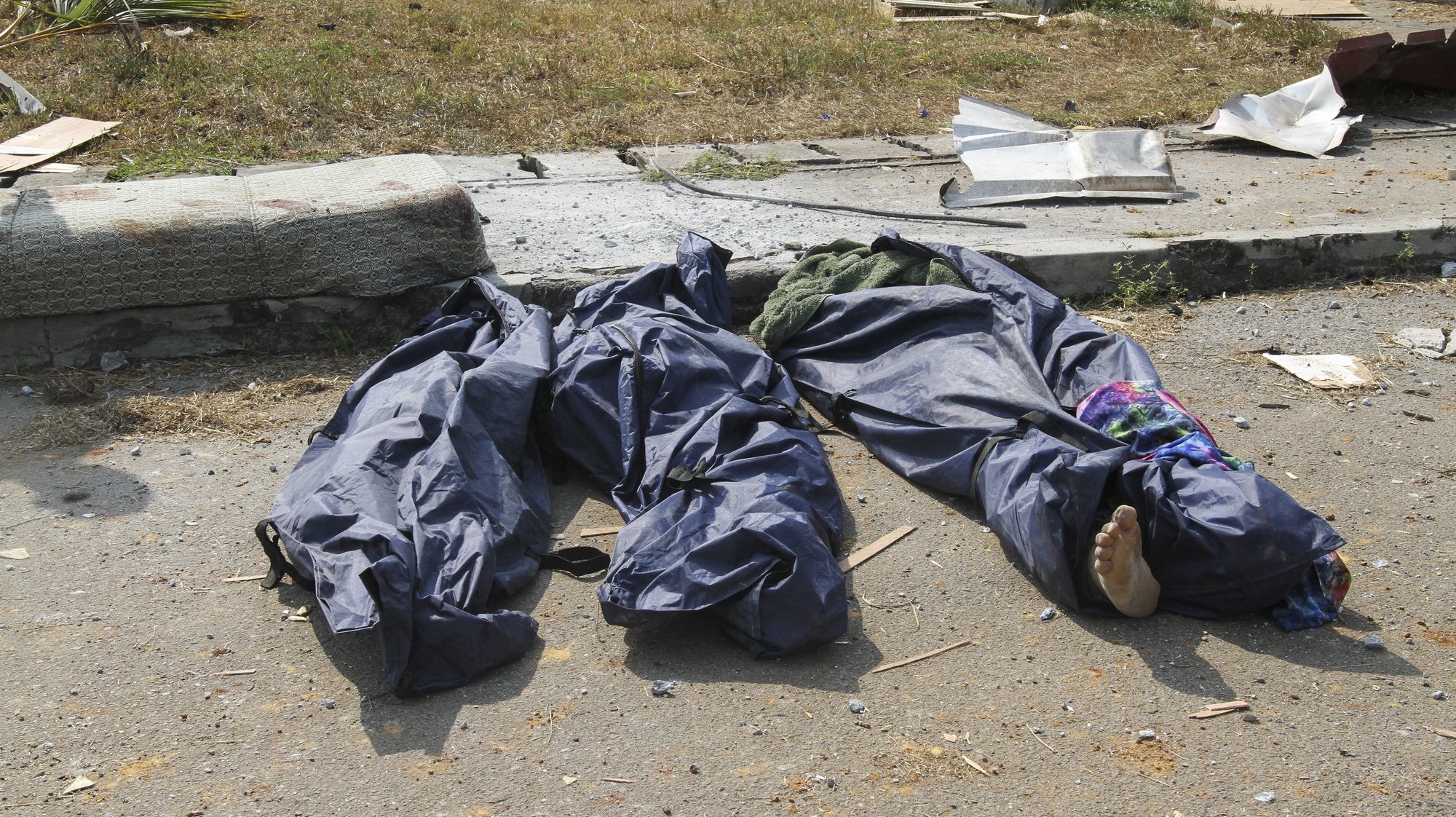 epa09062161 Bodies in body bags at the scene of the aftermath of an explosion in Bata, Equatorial Guinea, 08 March 2021. According to President Teodoro Obiang Nguema huge damage occured when a dynamite storage facility exploded in the port city of Bata on 07 March 2021. According to the Equatorial Guinea health ministry there is an initial count of 20 dead and 420 injured people are being treated in hospitals.  EPA/JOSE LUIS ABECARA AGUESOMO ATTENTION EDITORS: GRAPHIC CONTENT