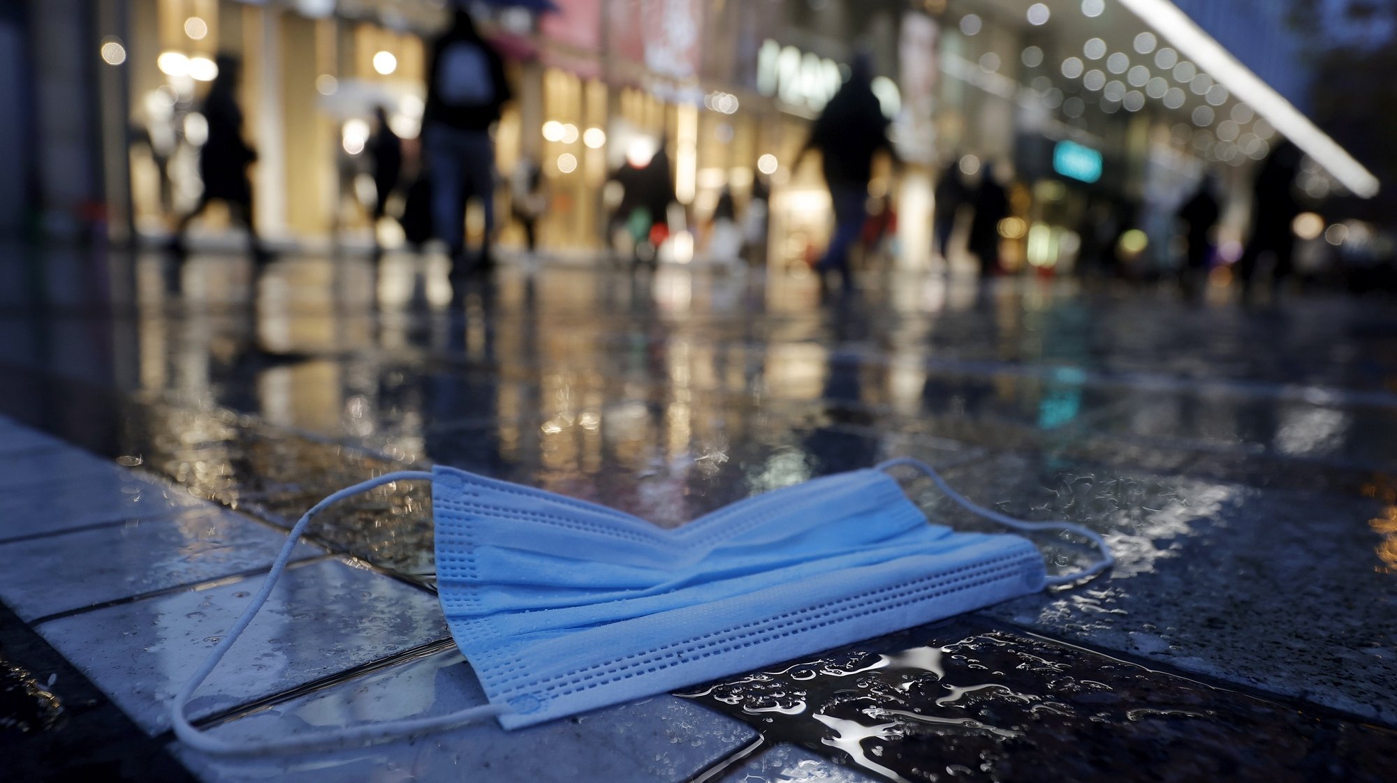 epaselect epa08885379 A protective face mask lies on the floor during shopping of the people in the city center at the &#039;Zeil&#039; in Frankfurt, Germany, 15 December, 2020. Due to an increasing number of cases of the COVID-19 pandemic caused by the SARS CoV-2 coronavirus, new nationwide restrictions have been announced to counteract a rise in infections, as the closing of the single store starting tomorrow 16 December.  EPA/RONALD WITTEK