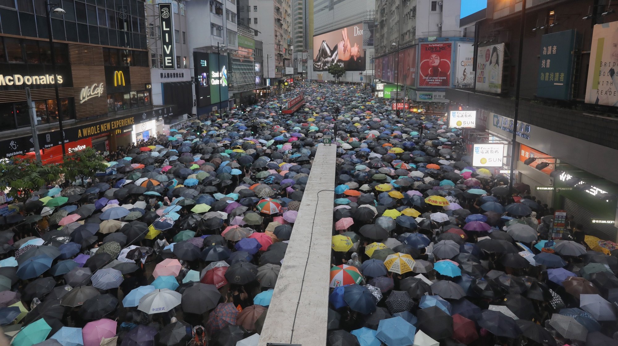 epa09109830 (FILE) - Protesters holding umbrellas amid heavy rain march in an anti-government rally in Causeway Bay, Hong Kong, China, 18 August 2019 (reissued 01 April 2021). Nine prominent democracy activists were convicted 01 April 2021 on unlawful assembly charges for their role in organizing the massive pro-democracy rally in Hong Kong on 18 August 2019.  EPA/VIVEK PRAKASH