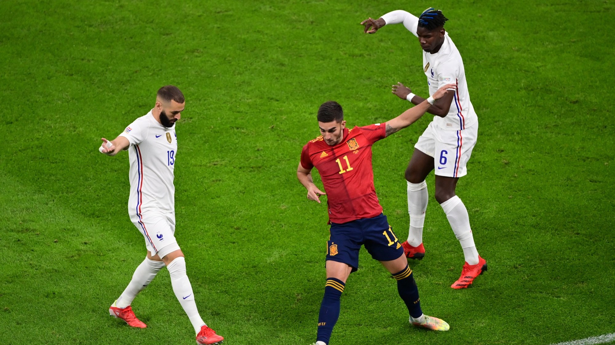 epa09517258 Spain’s Ferran Torres (C) in action against France’s Karim Benzema (L) and Paul Pogba (R) during the UEFA Nations League final between Spain and France in Milan, Italy, 10 October 2021.  EPA/Marco Betorello / POOL