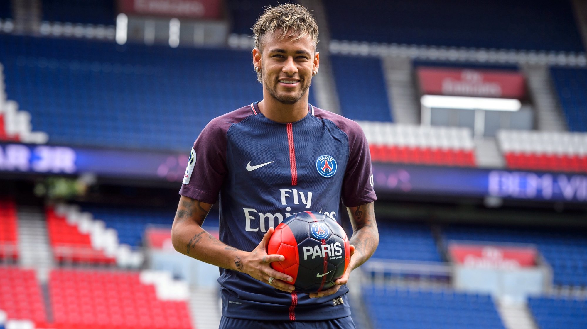 epa06124295 Brazilian striker Neymar Jr. poses for photographs with his new PSG jersey after a press conference at the Parc des Princes stadium in Paris, France, 04 August 2017. Neymar Jr is presented as new player of Paris Saint-Germain (PSG) after completing a record-breaking 222-million-euro move from Spanish side FC Barcelona.  EPA/CHRISTOPHE PETIT TESSON