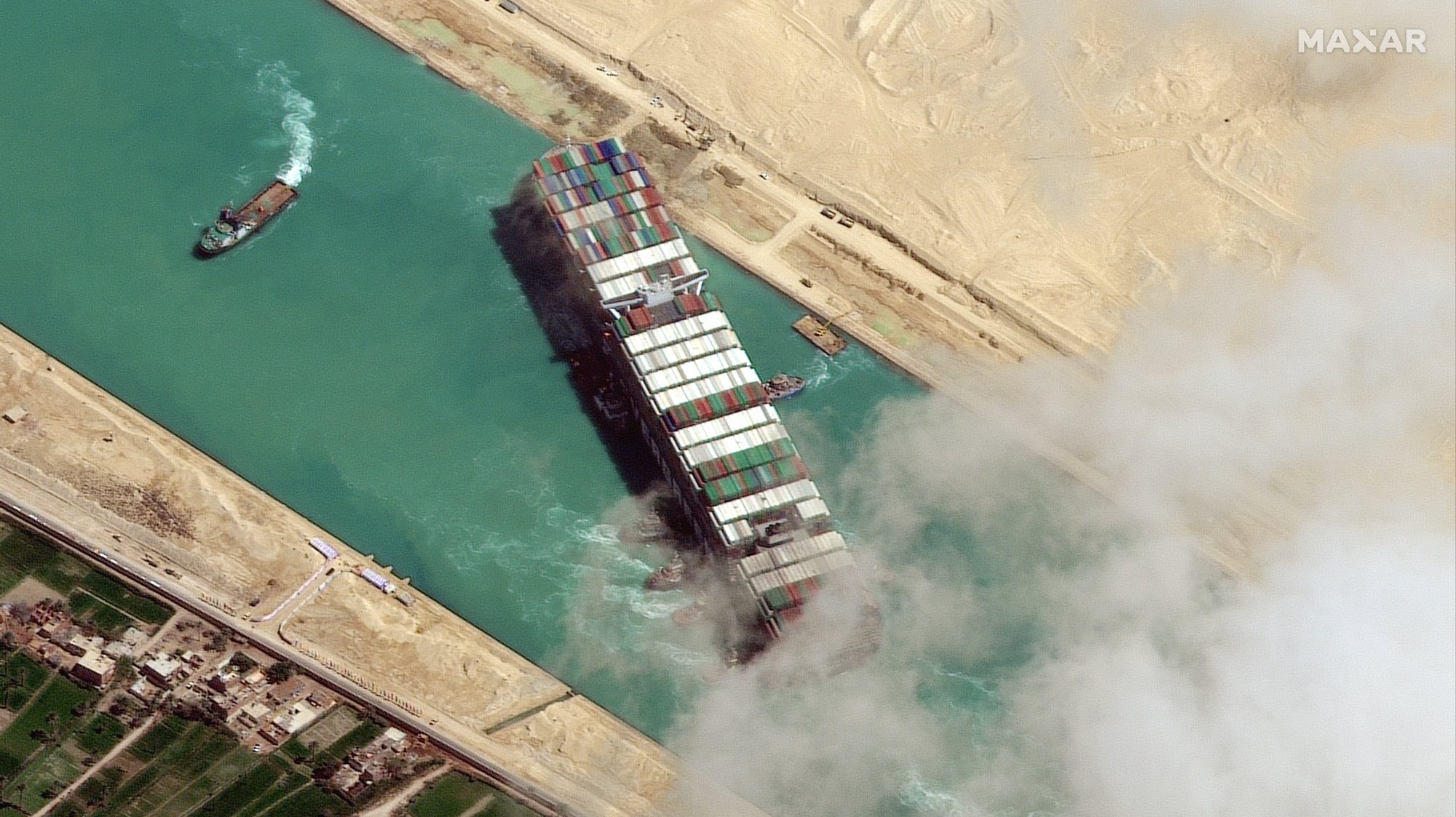 epa09105221 A handout satellite image made available by MAXAR Technologies shows , the Ever Given container ship after it has been moved away from the eastern bank of the canal and tugboats trying to reposition the ship, in the Suez Canal, Egypt, 29 March 2021. The head of the Suez Canal Authority announced on 29 March that the large container ship, which ran aground in the Suez Canal on 23 March, is now free floating after responding to the pulling maneuvers.  EPA/MAXAR TECHNOLOGIES HANDOUT --MANDATORY CREDIT: SATELLITE IMAGE 2021 MAXAR TECHNOLOGIES -- the watermark may not be removed/cropped -- HANDOUT EDITORIAL USE ONLY/NO SALES