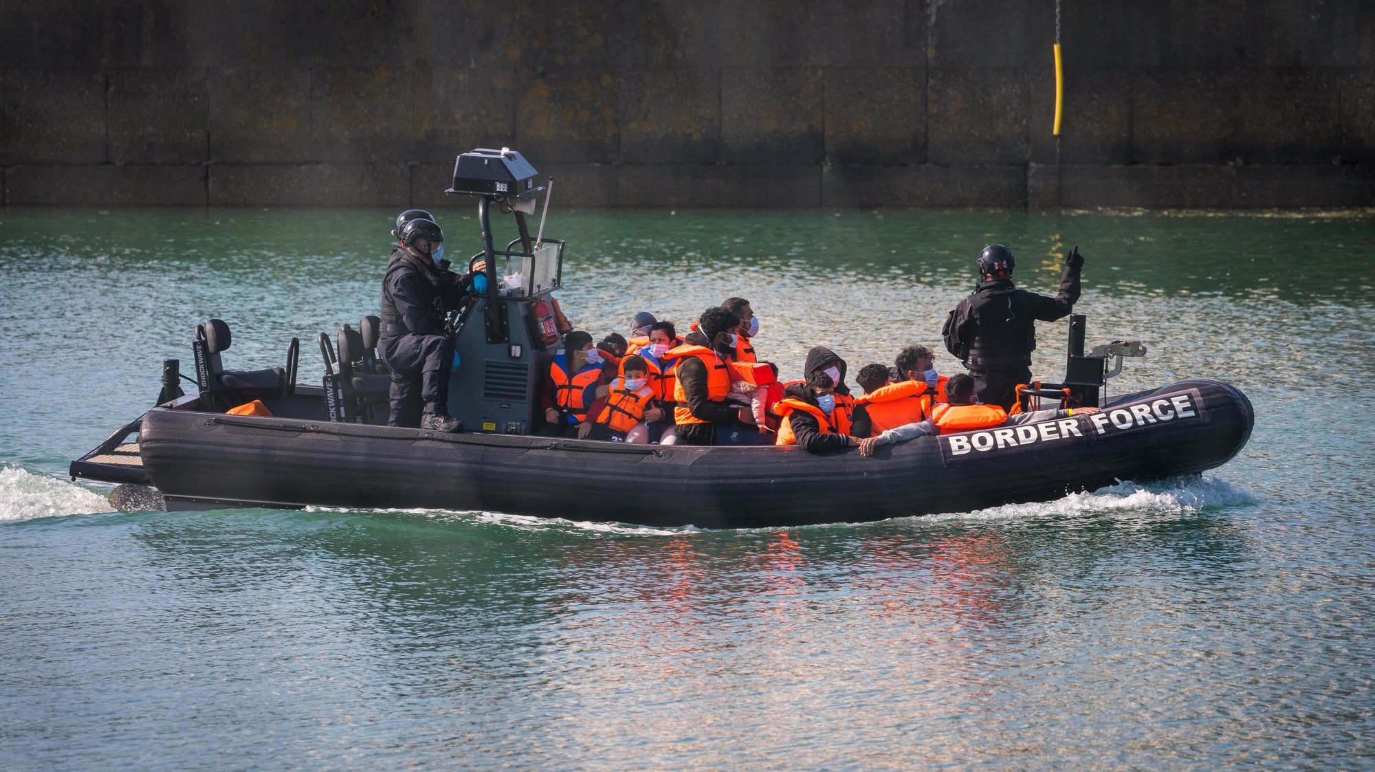 epa09358012 A boat from Britain&#039;s Border Force (BF) transports a group of people thought to be migrants, including children, who were found in the English Channel off the coast of Dover, in Dover, Kent, Britain, 22 July 2021. Britain and France are continuing ongoing talks in a bid to resolve the migrant crisis in the English Channel as migrants continue to arrive along the coast of the UK in their quest for asylum.  EPA/VICKIE FLORES