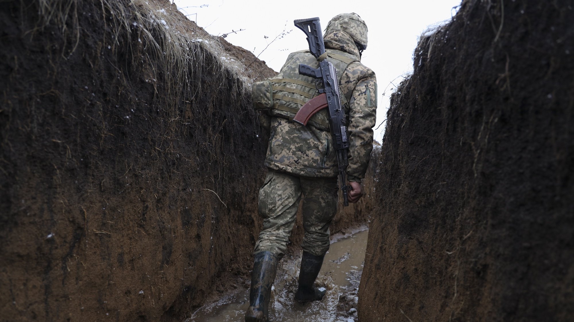epa09741653 A Ukrainian serviceman checks the situation at the positions on a front line near Zolote village, not far from where pro-Russian militants controlled city of Luhansk, Ukraine, 09 February 2022 amid escalation on the Ukraine-Russia border.  EPA/STANISLAV KOZLIUK