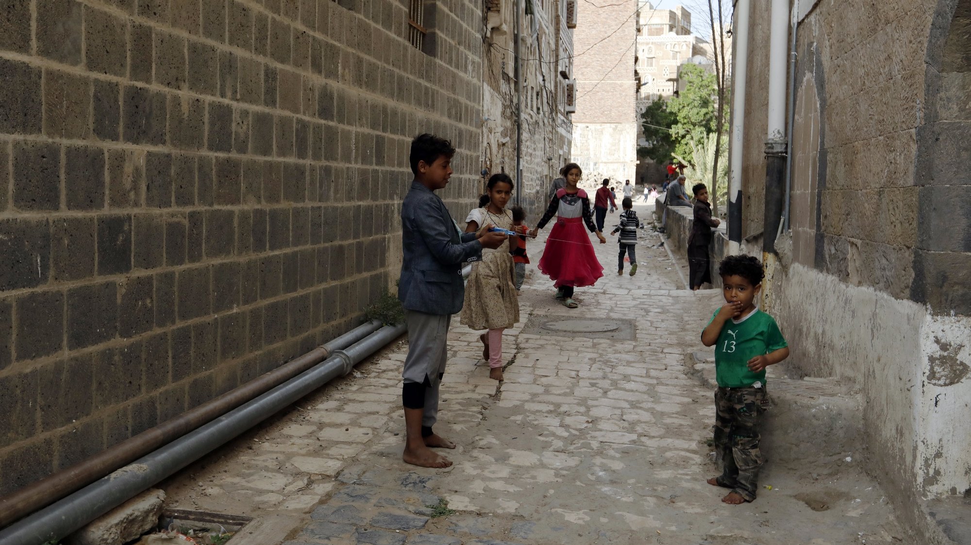 epa09223663 Yemeni children play at an alley in the old city of Sana’a, Yemen, 23 May 2021. The old city of Sana&#039;a is one of the oldest continuously-inhabited cities in the world. It was inscribed by UNESCO on the World Heritage List in 1986. It is made up of more than 6,000 buildings including its distinctive multi-story tower houses.  EPA/YAHYA ARHAB
