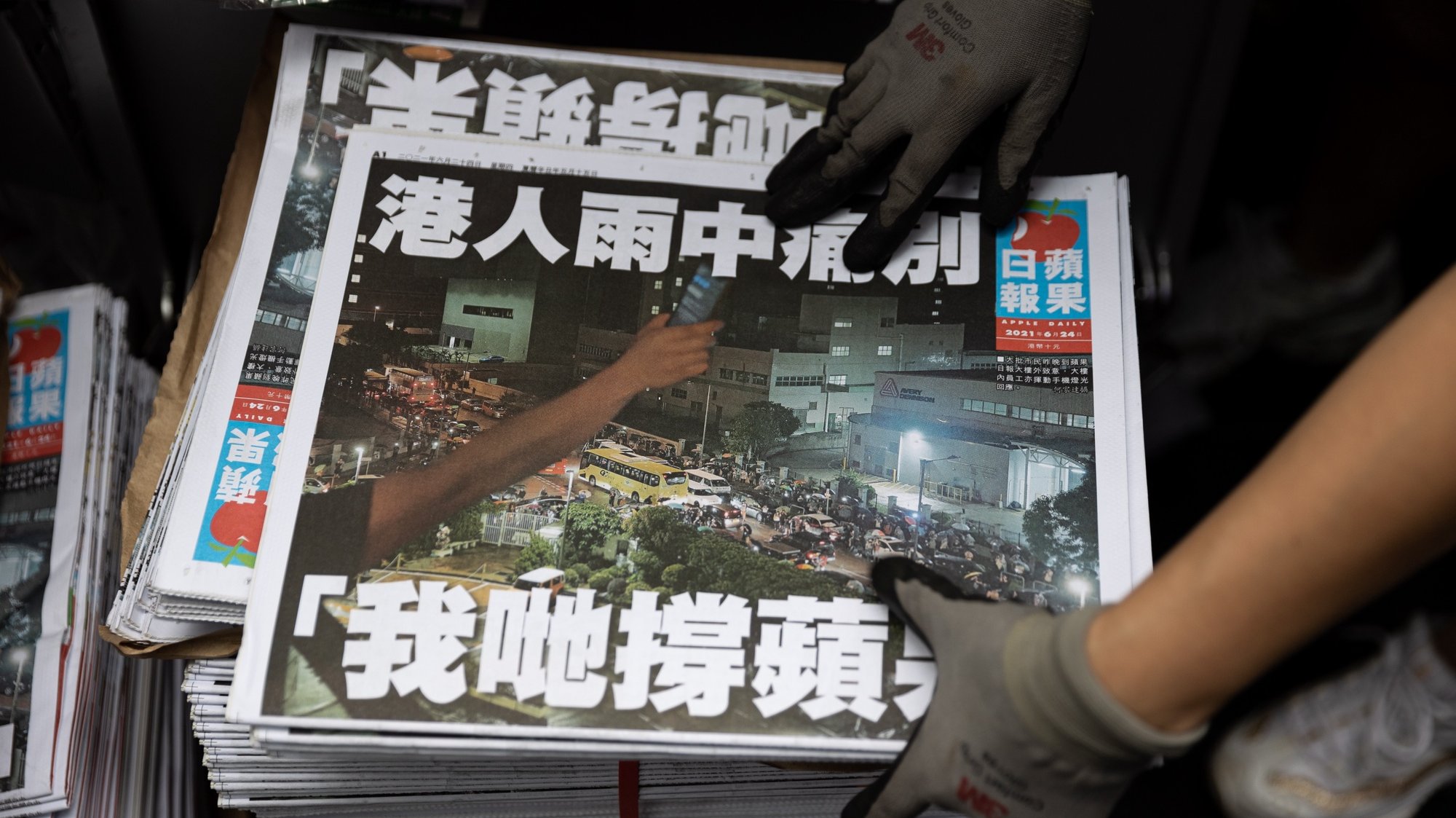 epa09297881 A salesperson stocks Apple Dailyâ€™s final issue at a news stand in Central, Hong Kong, China, 24 June 2021. The last edition of Apple Daily rolled off the presses three days earlier than expected, after management took into consideration the safety of its staff and manpower concerns.  EPA/JEROME FAVRE