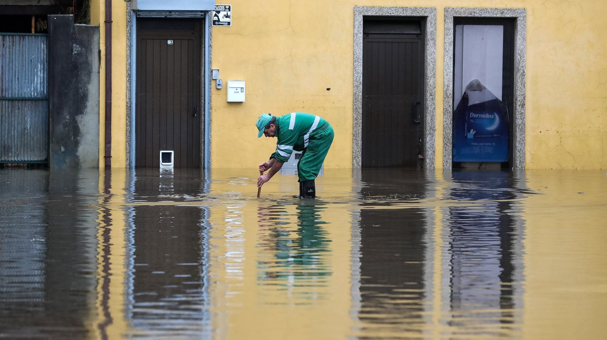 Um funcionário camarário limpa uma sargeta na zona ribeirnha da cidade de Águeda, que foi inundada pela subida da água do rio Águeda devido à chuva forte provocada pela depressão Elsa, em Águeda, 20 de dezembro de 2019. PAULO NOVAIS/LUSA