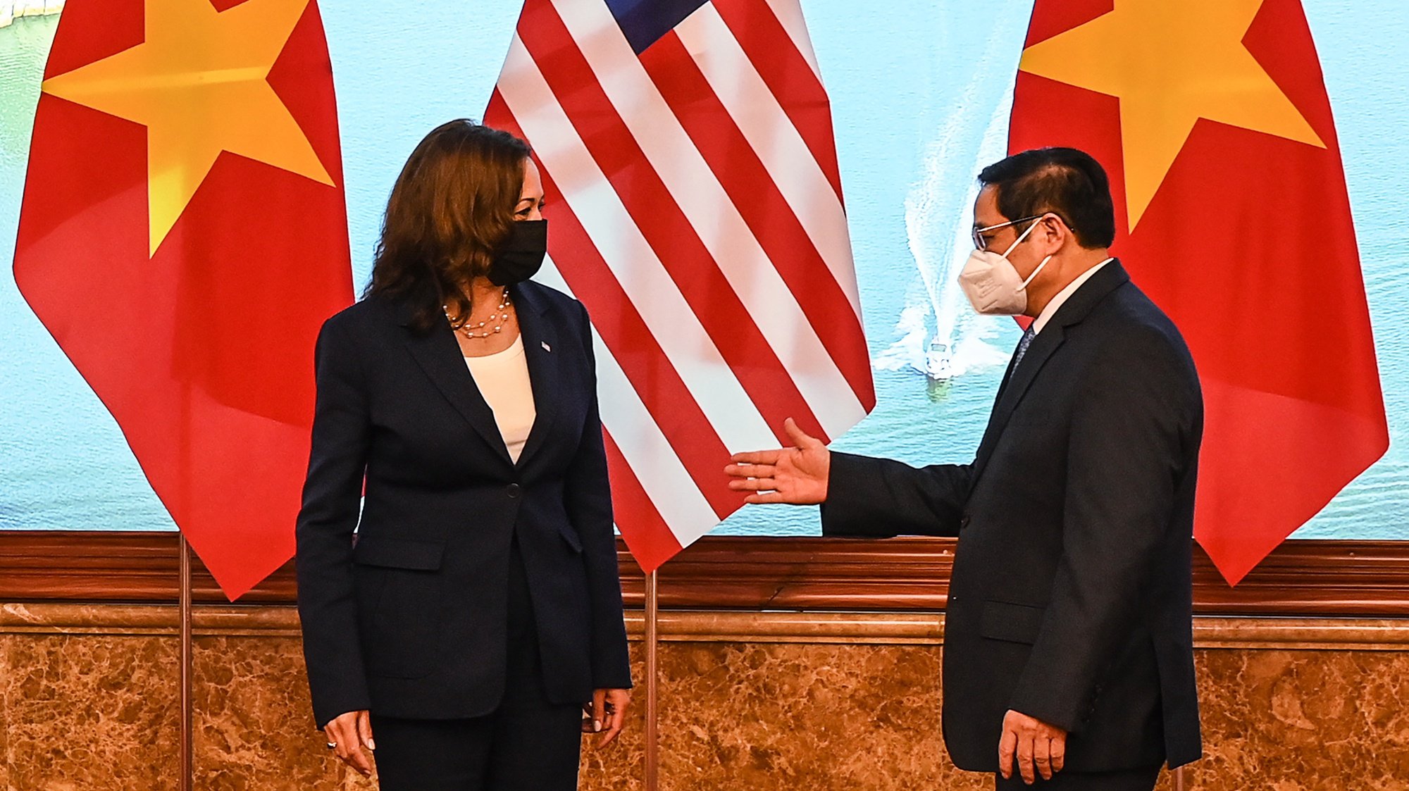 epa09428403 Vietnam&#039;s Prime Minister Pham Minh Chinh (R) gestures to US Vice President Kamala Harris (L) in the Government office in Hanoi, Vietnam, 25 August 2021.  EPA/MANAN VATSYAYANA / POOL