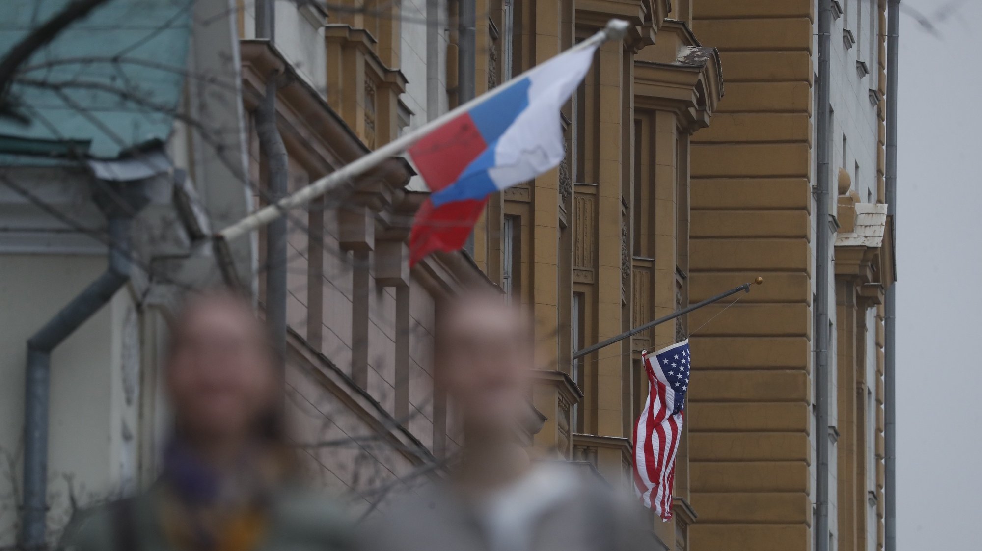 epa09137644 A Russian flag (L) next to the US embassy building in Moscow, Russia, 15 April 2021. Tensions have escalated between the US and Russia following the new sanctions announced by the United States against Russia.  EPA/MAXIM SHIPENKOV