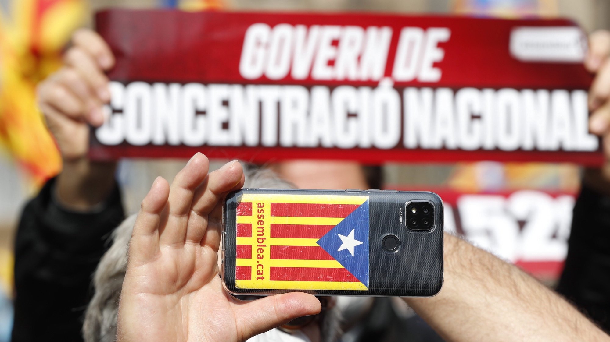 epa09042198 A Catalan pro-independent activist holds a cellphone picturing a pro-independent Catalan flag during a rally called by Catalan group ANC at Catalonia Square in Barcelona, Catalonia, Spain, 28 February 2020. The activists demand the formation a pro-independent Catalan regional Government after the 14 February regional elections.  EPA/Alejandro Garcia