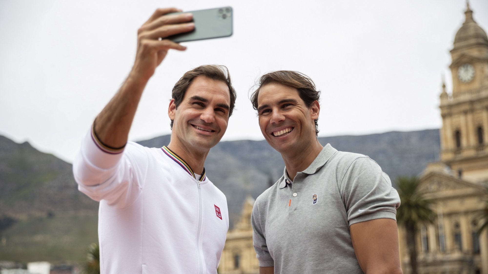 epaselect epa08199947 Roger Federer of Switzerland (L) and Rafael Nadal of Spain (R) take a selfie after playing mini tennis on the Cape Town Grand Parade infront of the City Hall and Table Mountain ahead of their exhibition match, South Africa 07 February 2020. Roger Federer will play Rafael Nadal in the Match in Africa Cape Town charity event at Cape Town Stadium on 07 February 2020. Presented by Rolex the Match in Africa is for the benefit of the Roger Federer foundation..  EPA/NIC BOTHMA