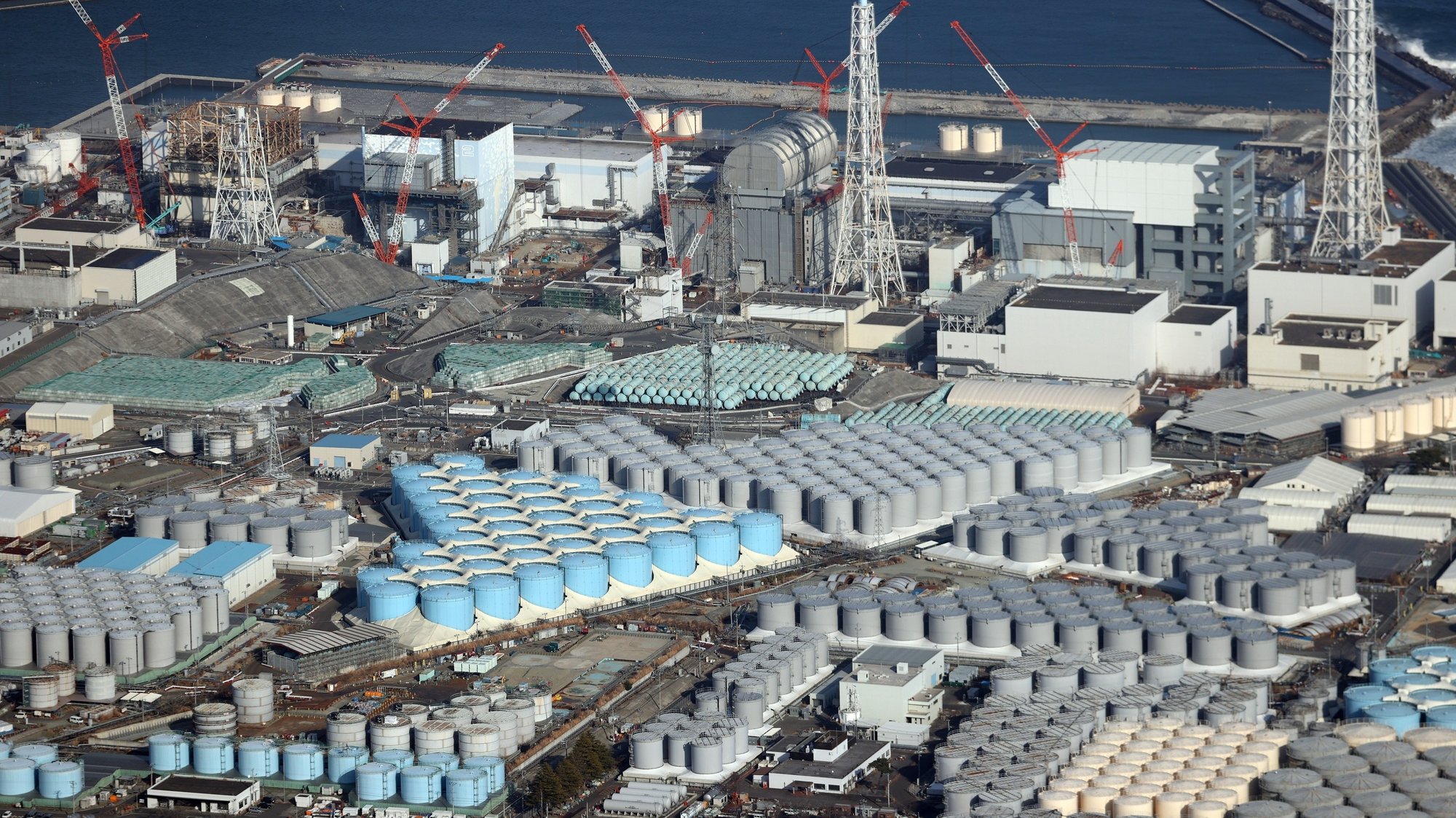 epa09123634 An aerial view shows tanks containing contaminated water at the Fukushima Daiichi nuclear power plant which suffered meltdowns on 11 March 2011, in Fukushima prefecture, northeastern Japan, 14 February 2021 (issued 09 April 2021). The Japanese government is to decide officially the release of treated water containing tritium from the crippled Fukushima Daiichi Nuclear Power Plant to the ocean at a cabinet meeting on 13 April.  EPA/JIJI PRESS JAPAN OUT EDITORIAL USE ONLY/  NO ARCHIVES