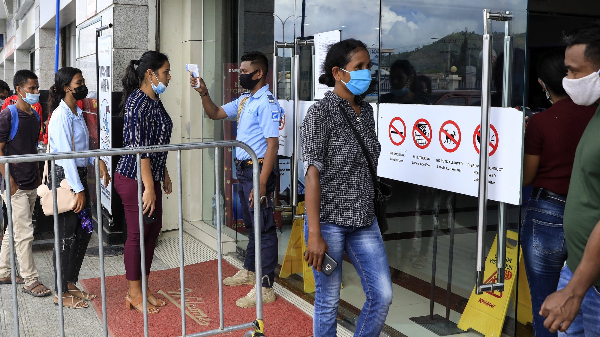 epa08936477 A security guard checks the body temperature of customers before they enter a shopping mall amid the ongoing COVID-19 disease pandemic in Dili, East Timor, also known as Timor Leste, 11 January 2021 (issued 14 January 2021). According to reports Timor Leste is considered successful in overcoming the pandemic and recorded as the second-smallest outbreak in Southeast Asia after Laos. Timor Leste has 49 cases with zero death while the neighbouring country Indonesia is struggling as one of the worst outbreaks in the region. The country imposed a state of emergency a week after the Catholic-majority nation reported its first case on 21 March 2020, and enforced strict border controls.  EPA/ANTONIO DASIPARU