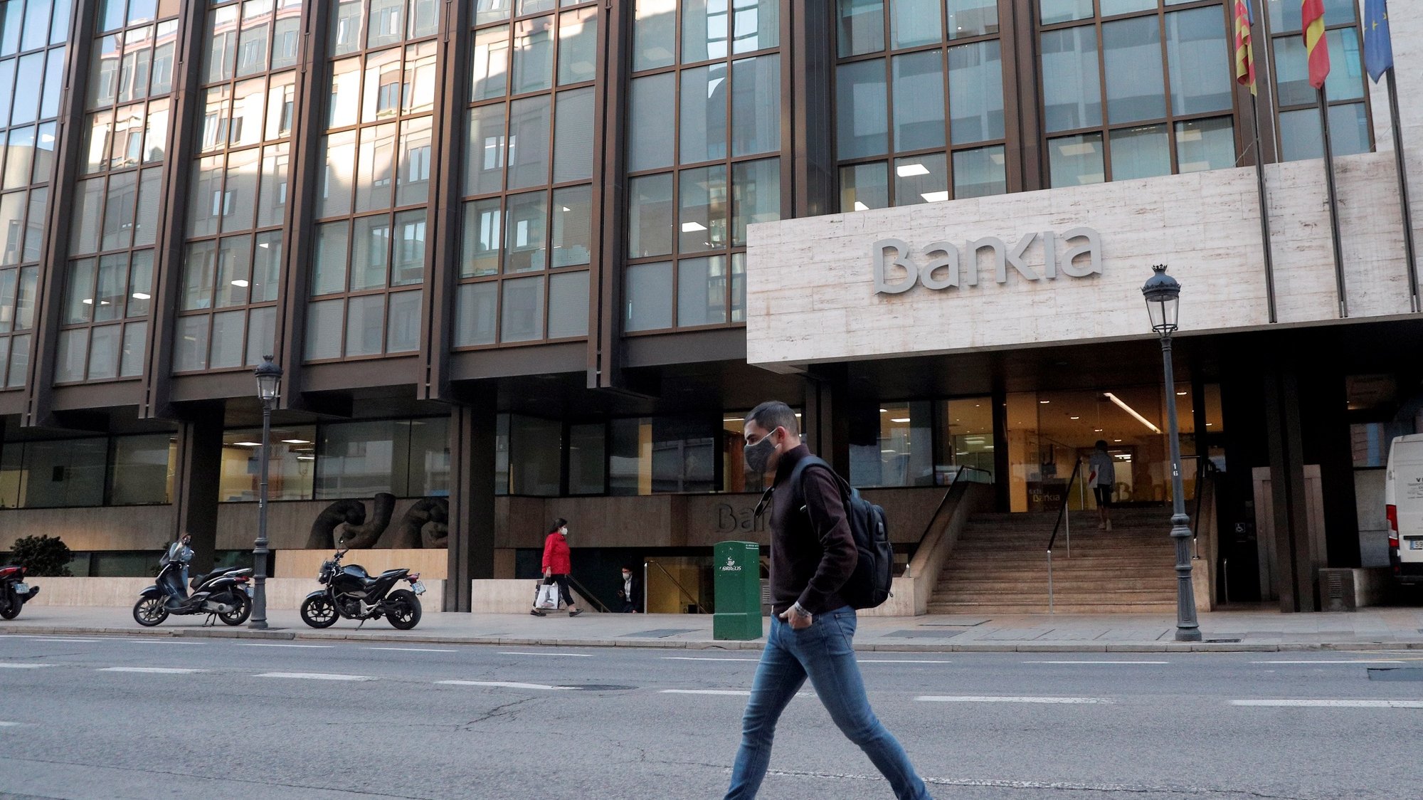 epa08767291 A passer-by walk past Spanish bank Bankia&#039;s offices in Valencia, Spain, 23 October 2020. The boards of directors of Spanish banks CaixaBank and Bankia are to meet during the day to put forward negotiation to the merge.  EPA/Kai Foersterling