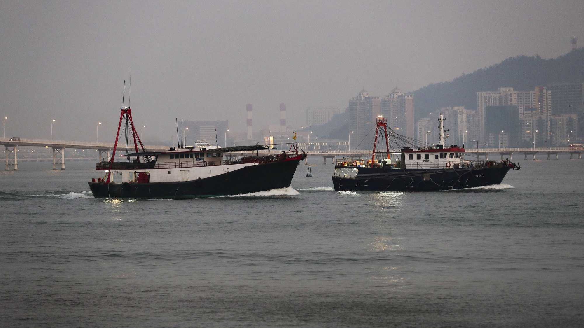 Barcos de pesca de Macau siem para a faina tendo como fundo edifícios da Taipa, Macau, China.17 de dezembro de 2019. JOÃO RELVAS/LUSA