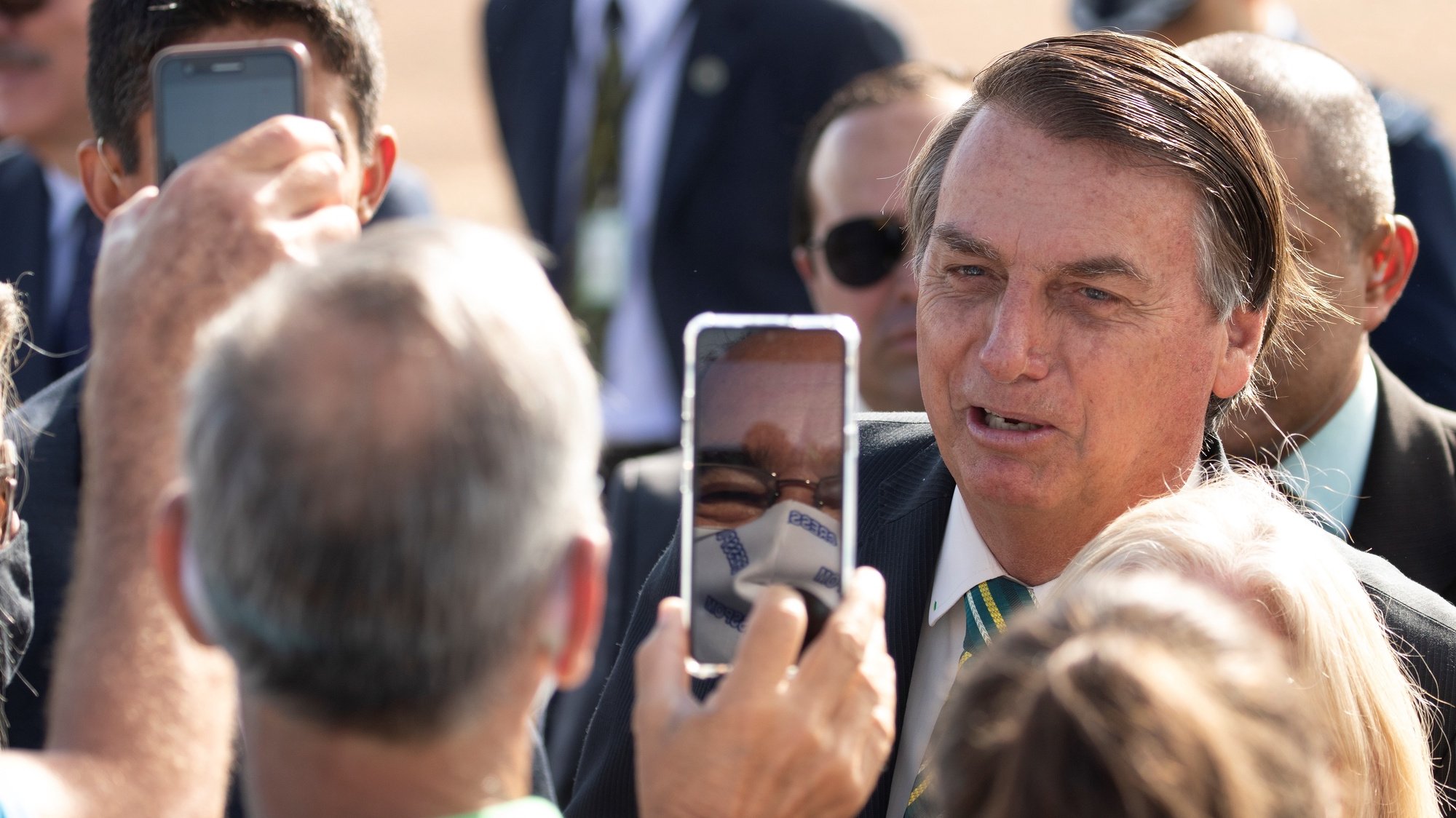 epa08777584 Brazilian President Jair Bolsonaro (C) poses for photos with his followers during the raising of the National Flag before the 38th Meeting of the Governing Council, at the Palace of the Alvorada, in Brasilia, Brazil, 27 October 2020.  EPA/Joedson Alves