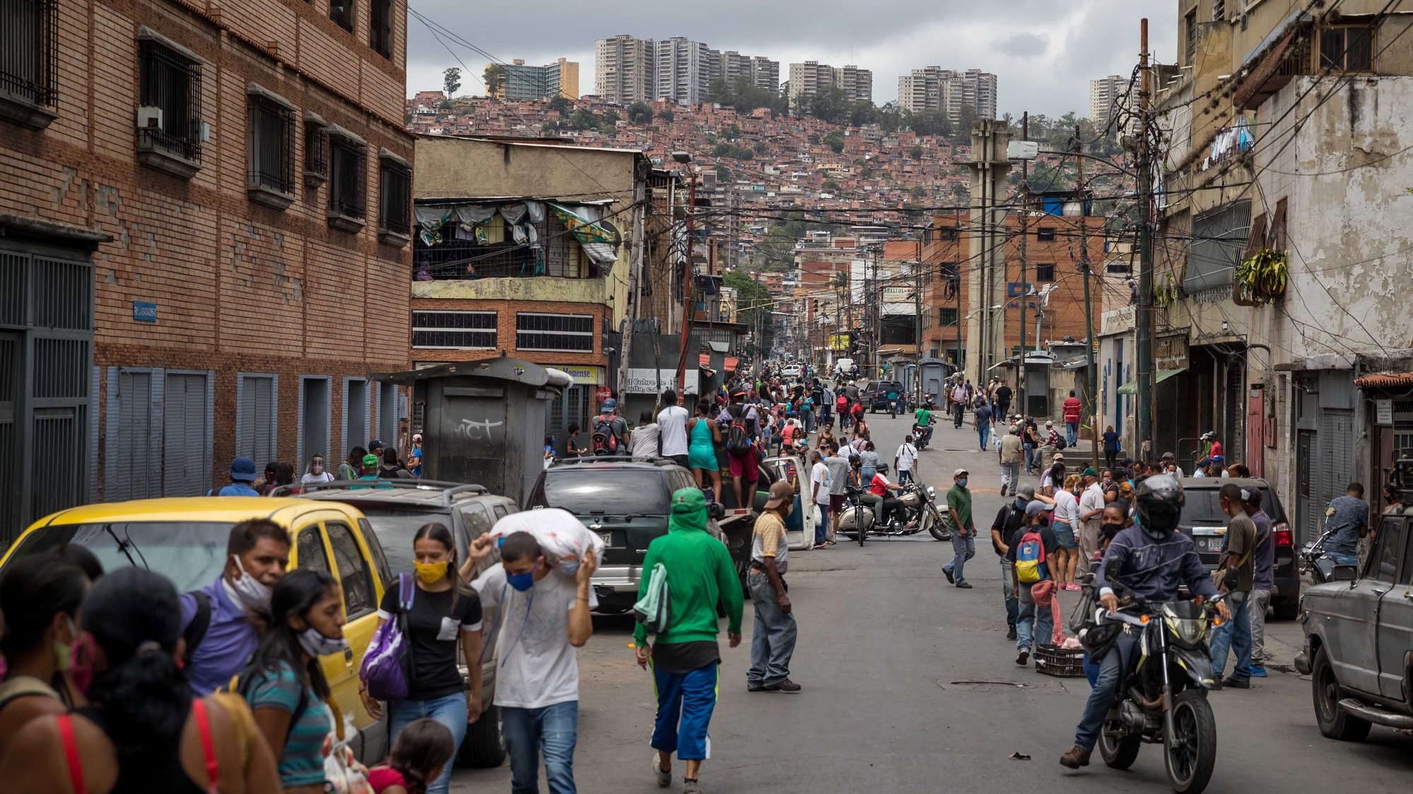 epa08547644 Dozens of people walk down a street in the Catia sector, in Caracas, Venezuela, 14 July 2020 (issued 15 July). Venezuela has been in coronavirus crisis mode for four months.  EPA/MIGUEL GUTIERREZ