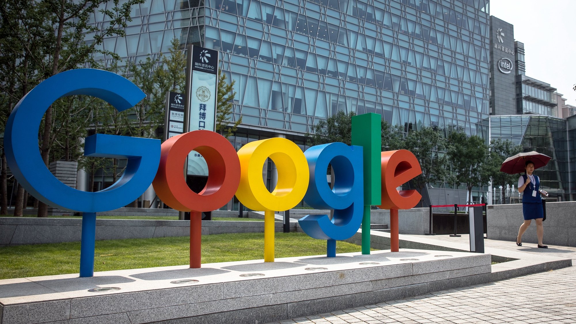 epa08979756 (FILE) - A Chinese woman walks past a &#039;Google&#039; brand name and logo, near the Google office in Beijing, China, 03 August 2018 (reissued 01 January 2021). Alphabet, the parent company of internet giant Google, is due to publish their 4th quarter 2020 results on 02 January 2021.  EPA/ROMAN PILIPEY *** Local Caption *** 54599547
