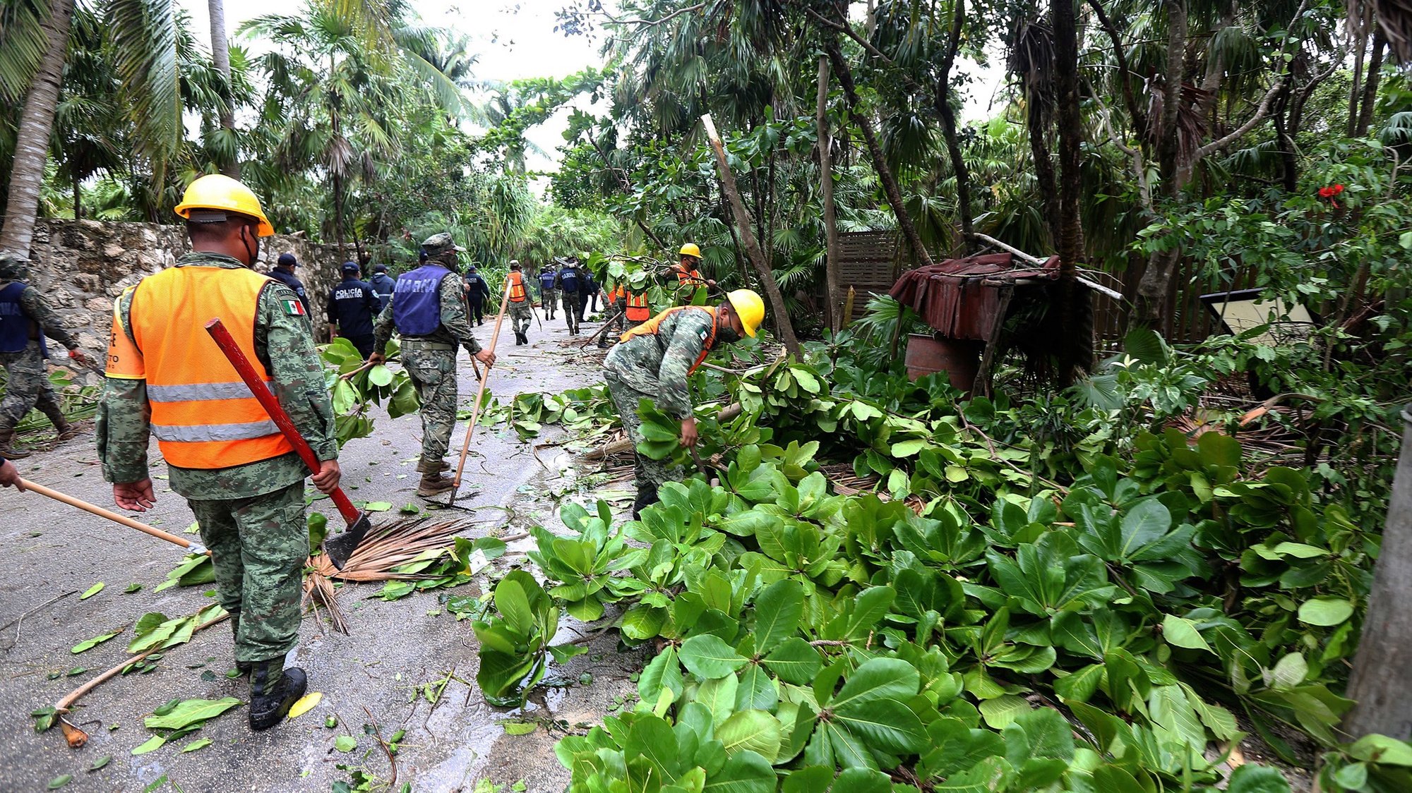 epa09421193 Members of the Mexican army walk by the areas affected by Hurricane Grace in Punta Allen, Quintana Roo state, Mexico, 19 August 2021. Hurricane Grace made landfall in the Mexican Caribbean, through the municipality of Tulum, bringing heavy rains.  EPA/Alonso Cupul