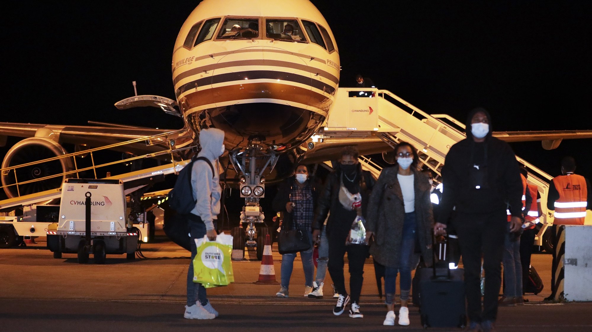 Passageiros saiem do avião da TACV - Transportes Aéreos de Cabo Verde S.A., no dia da  retoma dos voos 19 meses depois, no aeroporto internacional da Praia, Cidade da Praia, Cabo Verde, 27 de dezembro de 2021. ELTON MONTEIRO/ LUSA