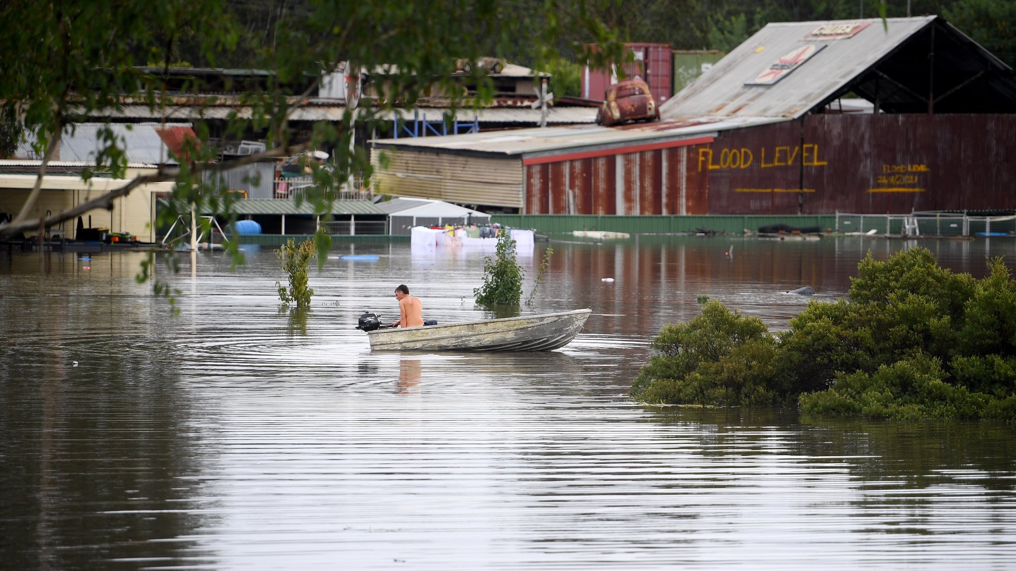 Jayden Evans utiliza o seu barco para conseguir aceder à sua casa, devido às inundações, em New South Wales, Austrália. 3 de março de 2022