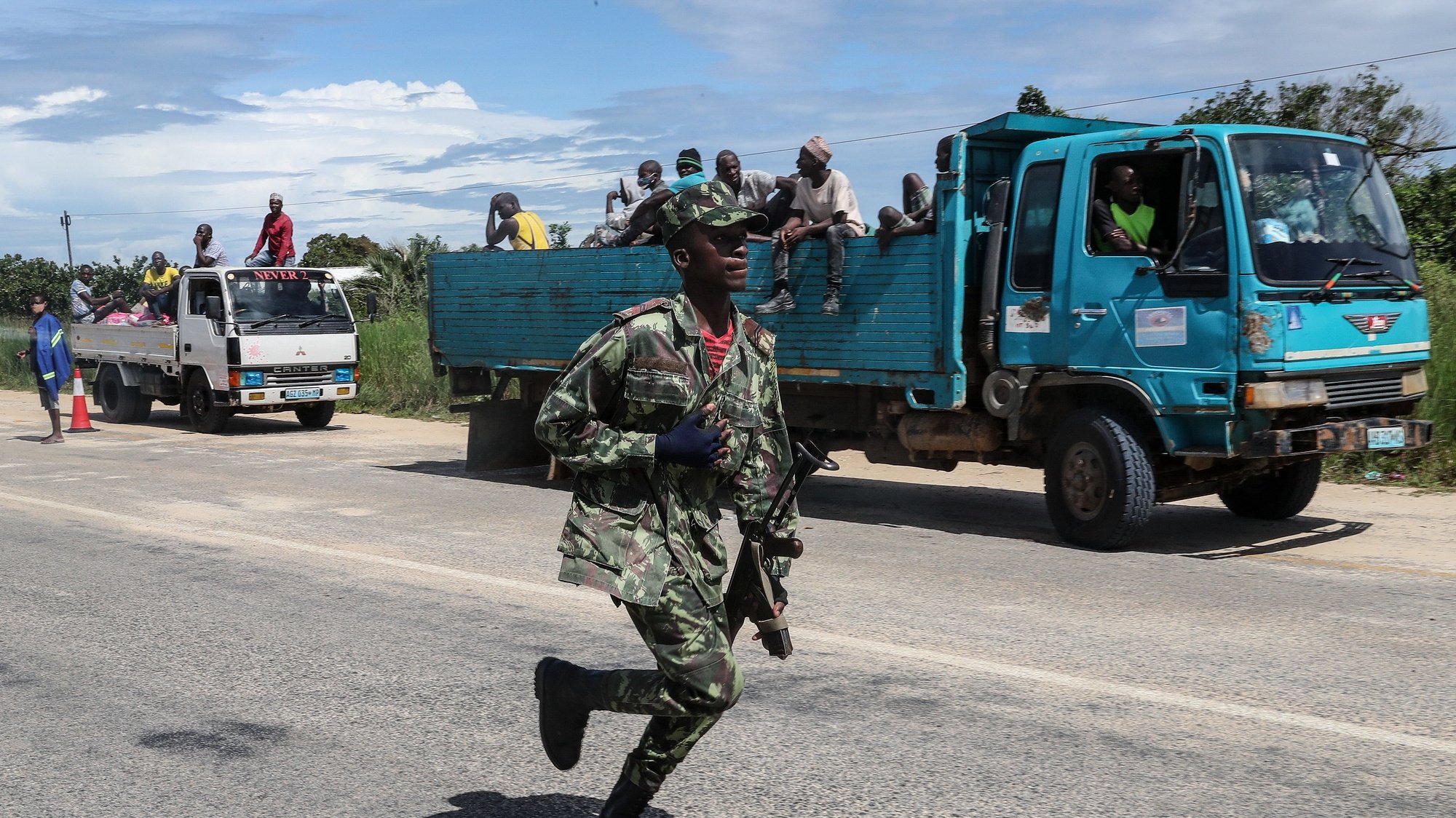 epa09125113 A Mozambique army soldier runs near a truck convoy with suplies to Palma, Cabo Delgado, Mozambique, 09 April 2021. The violence unleashed more than three years ago in Cabo Delgado province escalated again about two weeks ago, when armed groups first attacked the town of Palma.  EPA/JOAO RELVAS