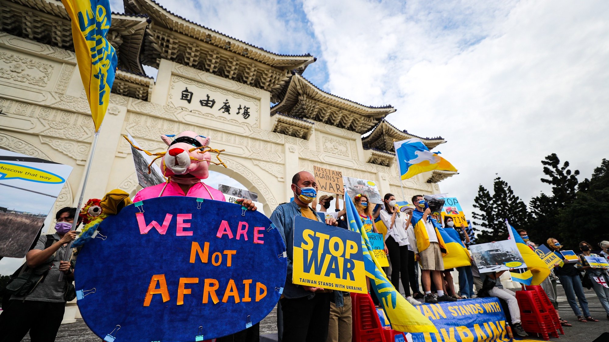 epa09933171 Protesters display placards and photos of war in Ukraine in front of the Liberty Square during a Victory Parade organized by Ukainians, in Taipei, Taiwan, 08 May 2022. Ukrainian citizens are calling the international community to support Ukraine against the Russian military campaign in the country.  EPA/RITCHIE B. TONGO