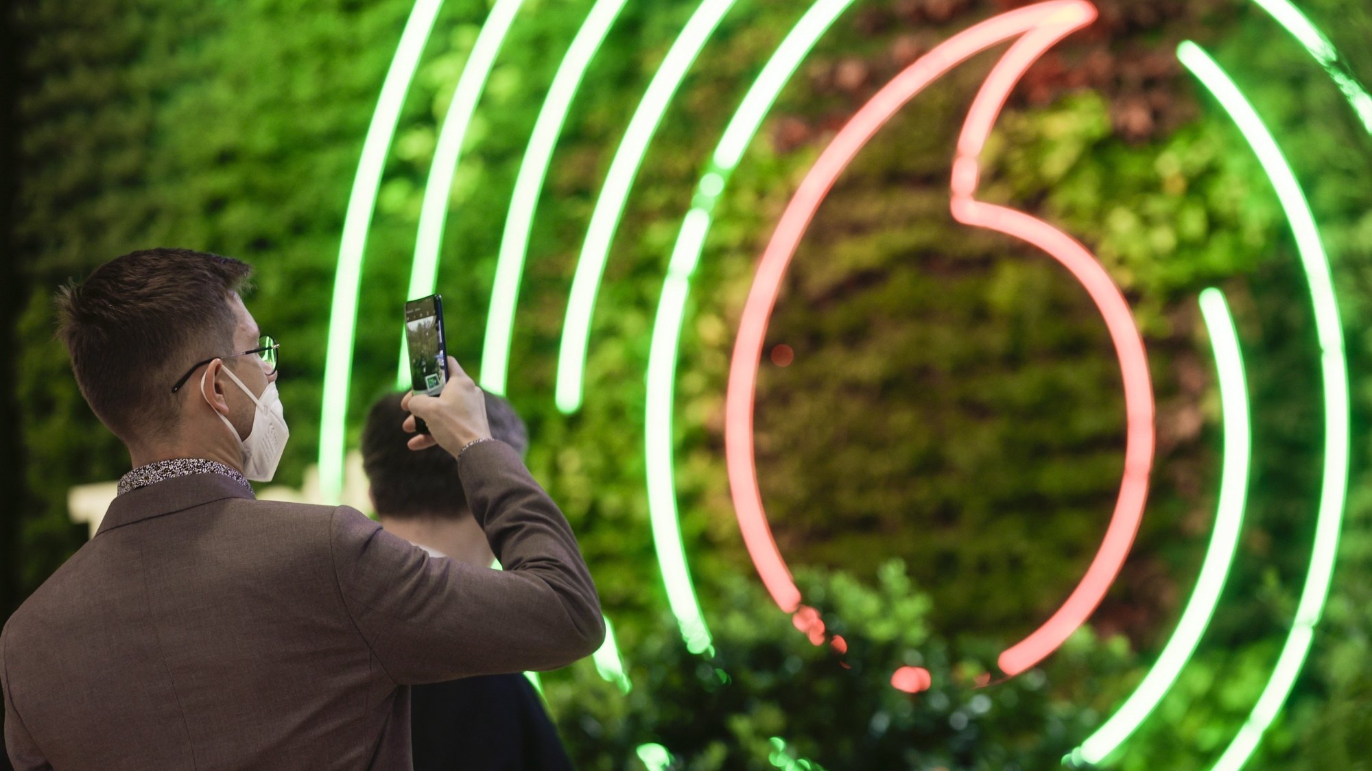 epa09798772 A visitor takes a photo of a vertical garden at Vodafone exhibitior at Mobile World Congress (MWC), in Barcelona, northeastern Spain, 03 March 2022. Vodafone launched ten exhibitions of key network technologies for green transition under the motto &#039;Digital for Green&#039;. The Mobile World Congress, running from 28 February to 03 March 2022, is the largest technology fair in the world.  EPA/QUIQUE GARCIA