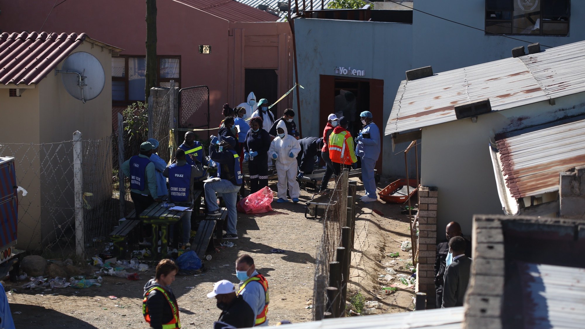 epa10034985 South African Police Forces (SAPS) and forensics experts work at the scene where an estimated 20 young people died in Enyobeni Tavern in East London, South Africa, 26 June 2022. The cause of death of the youngsters is yet to be established as 20 people died and 3 others have been hospitalized after an apparent party occurred overnight at the tavern.  EPA/STR