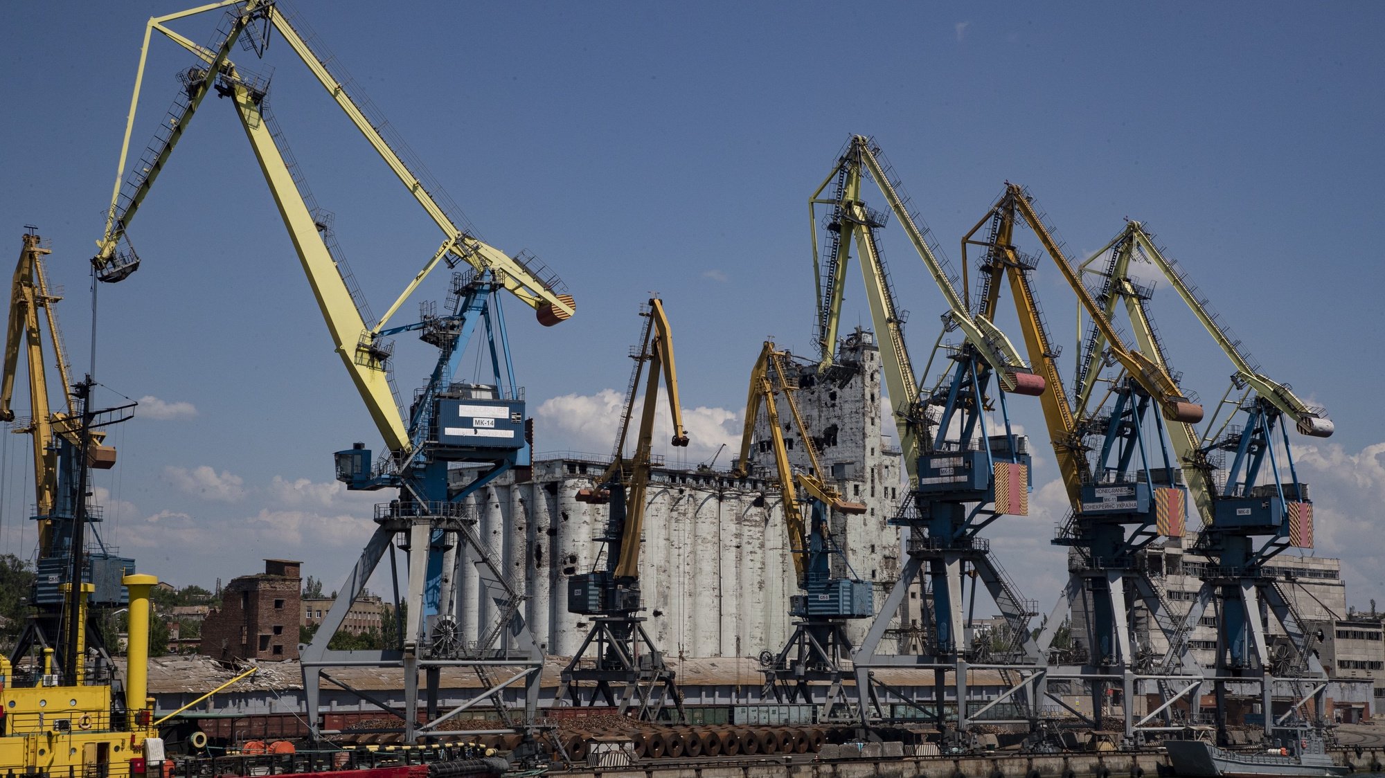 epa10009881 A picture taken during a visit to Mariupol organized by the Russian military shows Russian ships moored at a pier in front of destroyed granary in the cargo sea port of Mariupol, Ukraine, 12 June 2022. Russian Defense Minister Sergei Shoigu said the seaports of Mariupol and Berdyansk in Ukraine are operating normally and are ready to ship grain.  According to Shoigu, demining of the Mariupol seaport has been completed and it is functioning normally and has received the first cargo ships. Shoigu added ‘In Mariupol, water and electricity supply to residential areas are gradually being restored, streets are being cleared, the first social facilities have begun to function.’ On 24 February Russian troops entered Ukrainian territory starting a conflict that has provoked destruction and a humanitarian crisis. According to the UNHCR, more than six million refugees have fled Ukraine, and a further 7.7 million people have been displaced internally within Ukraine since.  EPA/SERGEI ILNITSKY