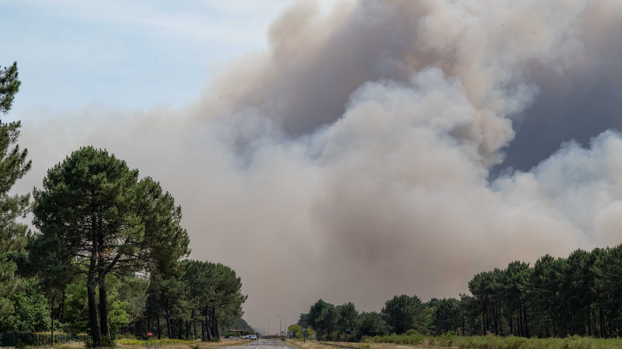 epa10071170 View of a cloud of smoke from a forest fire at La Teste de Buch, France, 14 July 2022. Nearby, in Cazaux, the evacuation of the town, air base and campsites was ordered. These evacuations are in addition to the 6,700 people already evacuated since the start of the fires in the Gironde area which is facing  two wildfires, one of them being the largest the region has seen in 20 years, with 2,800 hectares burned.  EPA/CAROLINE BLUMBERG