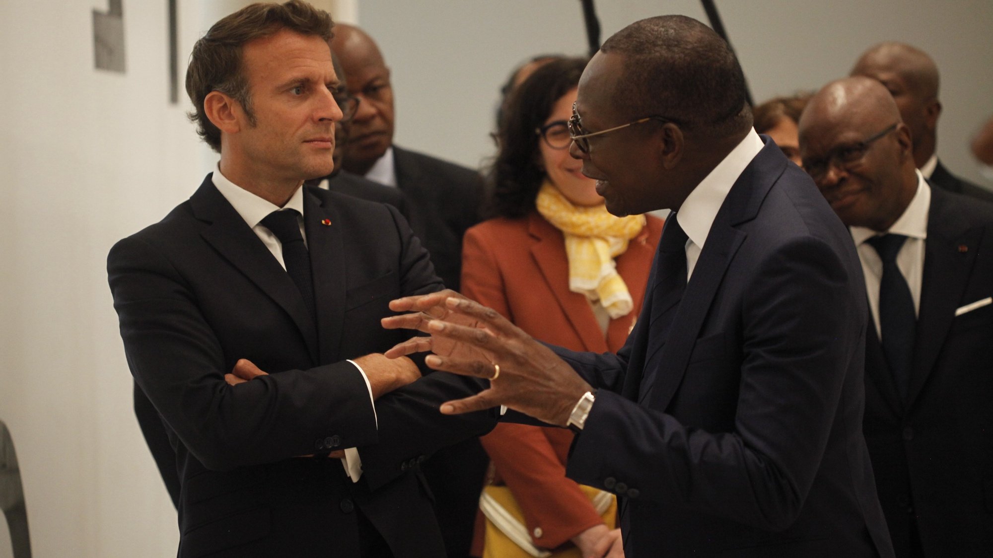 epa10094145 French President Emmanuel Macron (L) speaks with President Patrice Talon of Benin Republic as he attends the opening of a hybrid art exhibition in Cotonou, Benin, 27 June 2022, during the official visit of Macron to the Republic of Benin.  EPA/AKINTUNDE AKINLEYE
