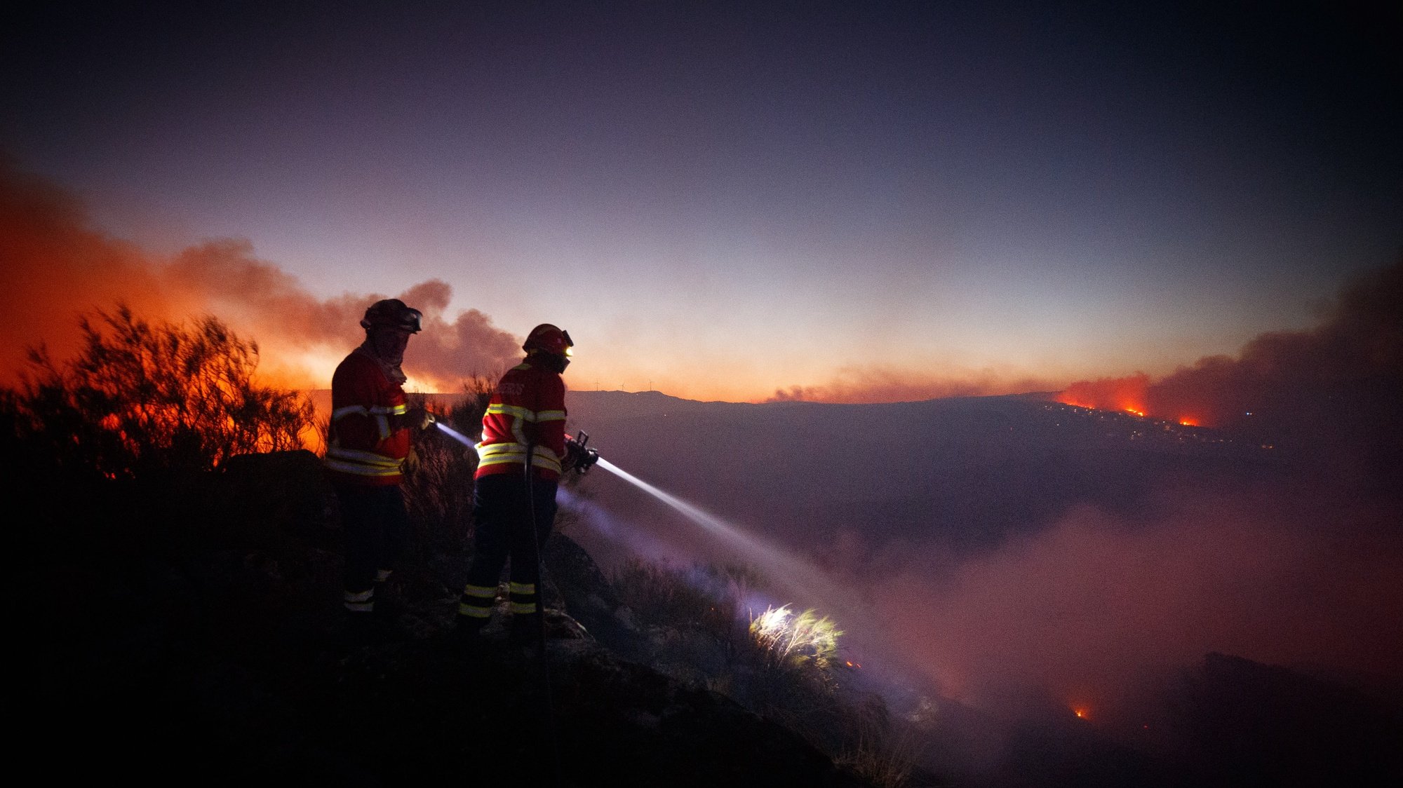 epa10096563 Firemen fights a forest fire in Reboredo village, Vila Pouca de Aguiar, Portugal, 28 July 2022. A total of 466 operational, 144 vehicles and six airplane are fighting the forest fire.  EPA/PEDRO SARMENTO COSTA