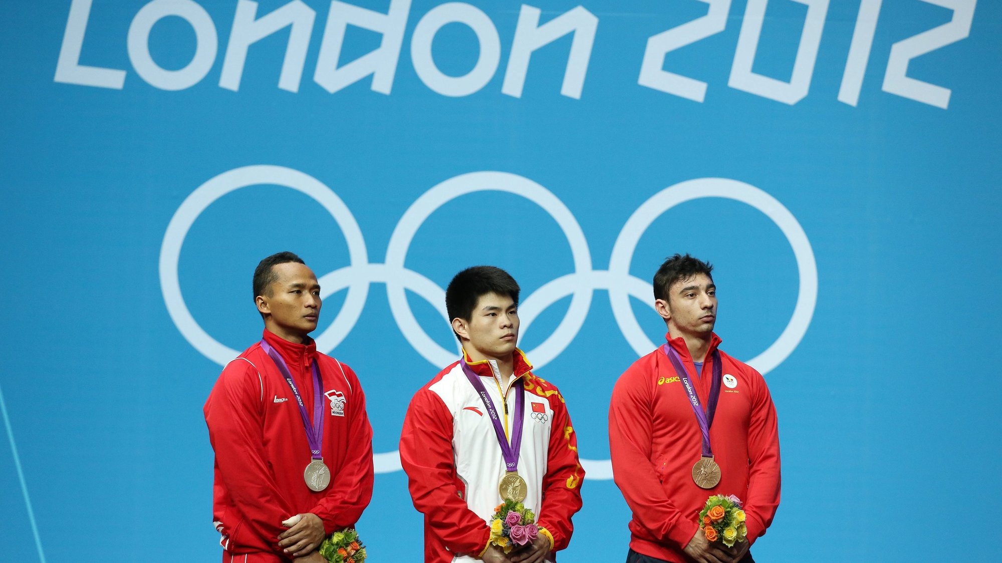 epa03330876 (L-R) Silver medalist Triyatno Triyatno of Indonesia, gold medalist Qingfeng Lin of China and bronze medalist Constantin Razvan Martin of Romania during the medal ceremony in the men&#039;s 69 kg category in the London 2012 Olympic Games weightlifting competition, London, Great Britain, 31 July 2012.  EPA/LINDSEY PARNABY