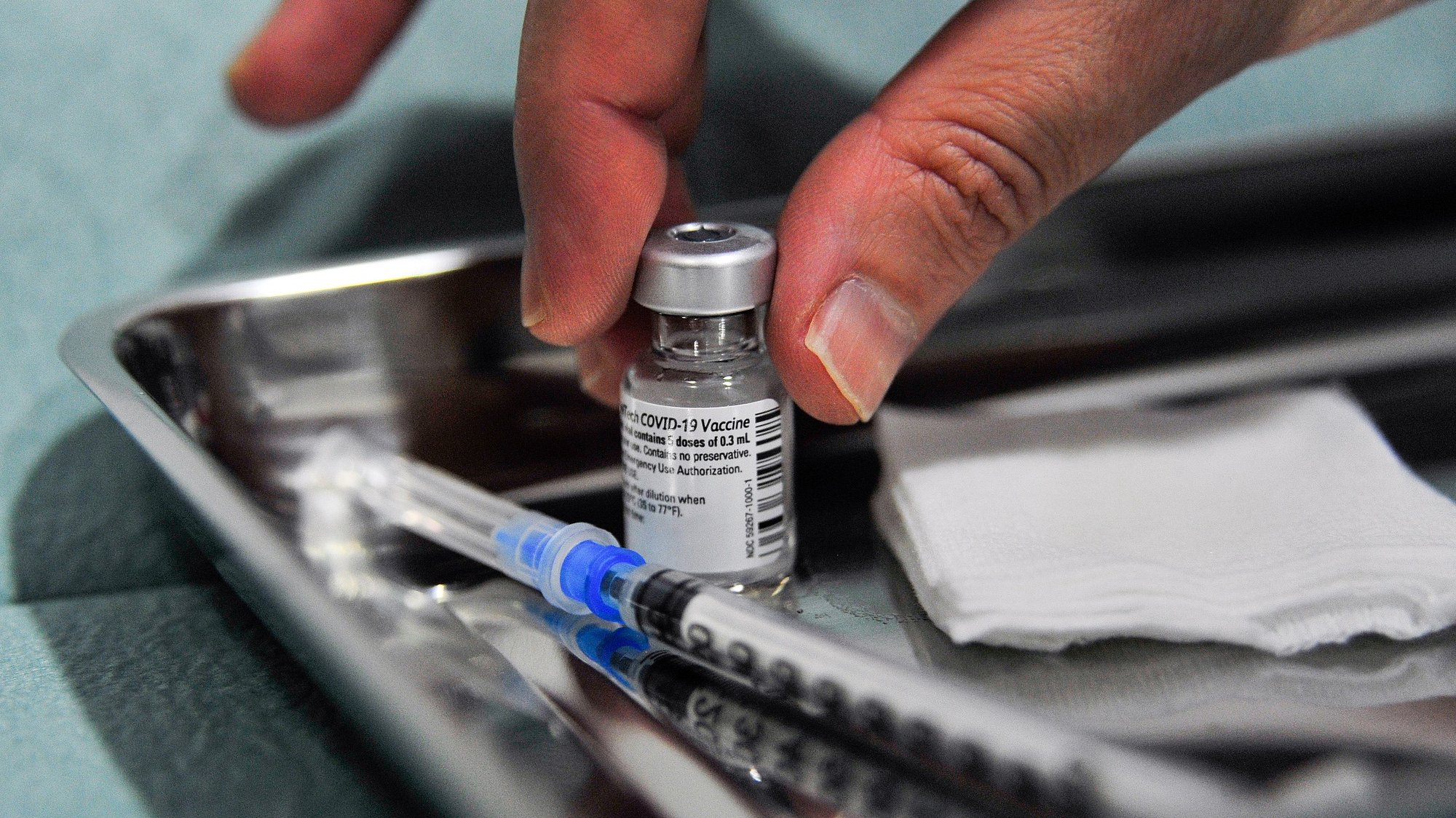 Uma profissional da saúde prepara uma dose da vacina da Pfizer-BioNTech contra a covid-19 para ser administrada ao pessoal clínico do Centro de Saúde do Oeste, na unidade do Centro de Saúde das Caldas da Rainha, 29 de dezembro de 2020. CARLOS BARROSO/LUSA