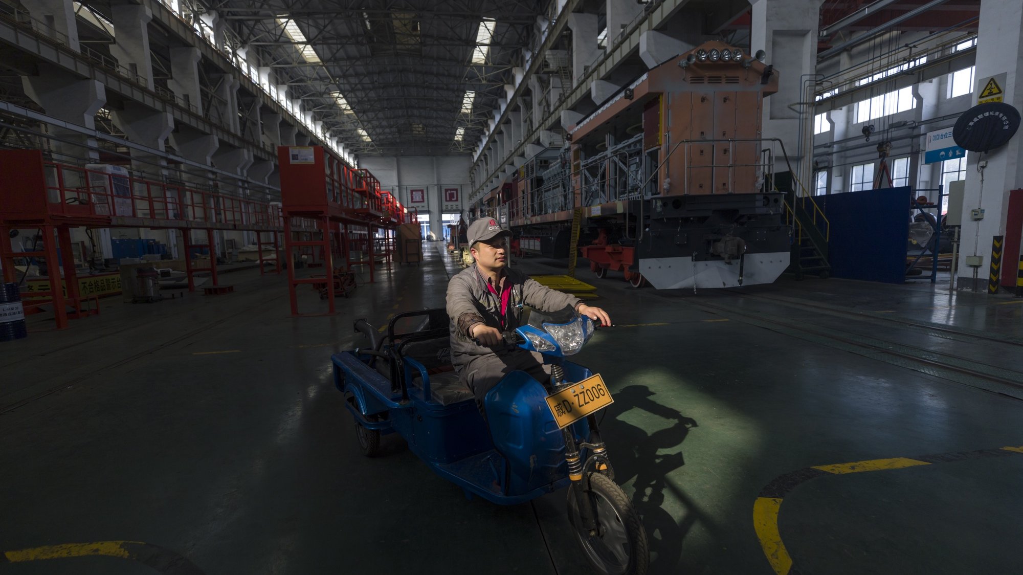 epa09627032 A worker drives parts in a motorcycle in a CRRC Qishuyan Institute locomotives factory, during the organised media tour in Changzhou, Jiangsu province, China, 07 December 2021. CRRC Qishuyan Institute Co., Ltd. is located in Changzhou Economic Development Zone, Jiangsu, in the middle section of Shanghai-Nanjing Railway. It is an important R&amp;D, manufacturing and maintenance base for railway passenger and freight diesel locomotives in the country. It exports to more than 20 countries and regions including Australia, Argentina, Venezuela, Kenya, Thailand, and Cambodia.  EPA/ALEX PLAVEVSKI