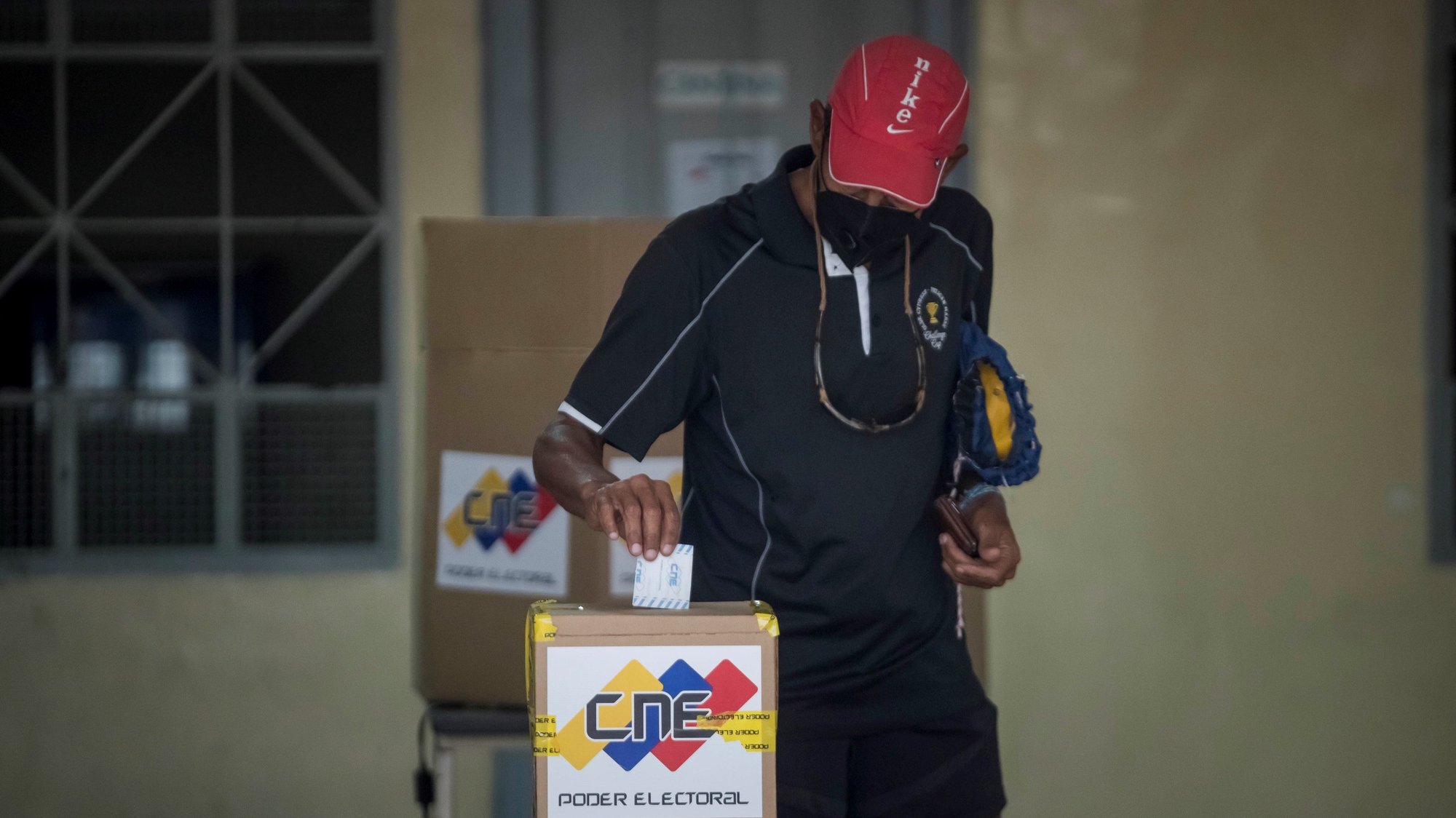 epa08867315 A voter casts his vote in a ballot box in a polling station during Parliamentary elections, in Caracas, Venezuela, 06 December 2020. Venezuelans were called to polls to select 277 members of the National Assembly. The opposition has called for a boycott of the elections, on grounds that the contest will not be free and fair.  EPA/Miguel Gutierrez