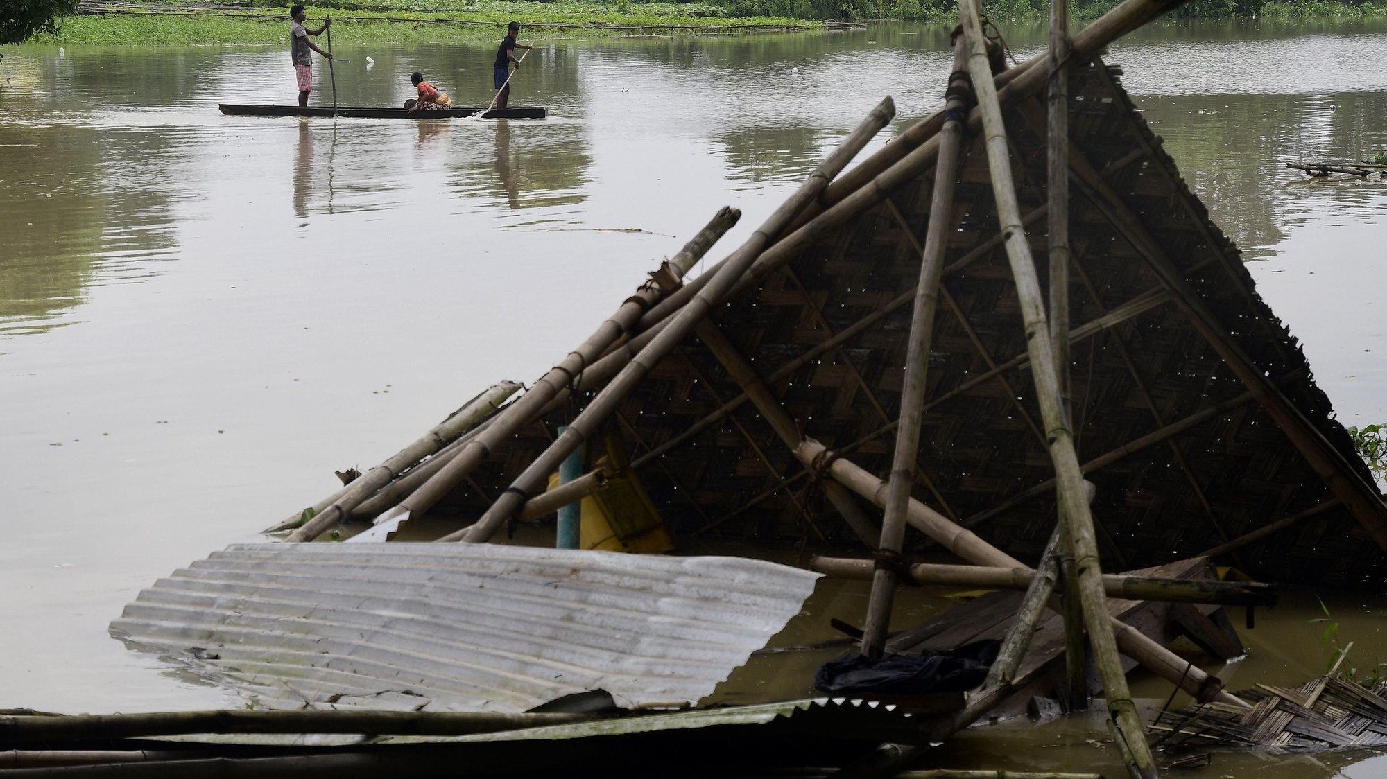 epa10023694 Indian villagers move to a safe place in the flood-affected area of Morigaon district in Assam, India, 20 June 2022. According to state government officials, over 200,000 people were being sheltered across 744 relief camps, while over 30,000 others were evacuated, as the death toll from floods and landslides in the state rose to at least 73.  EPA/STR