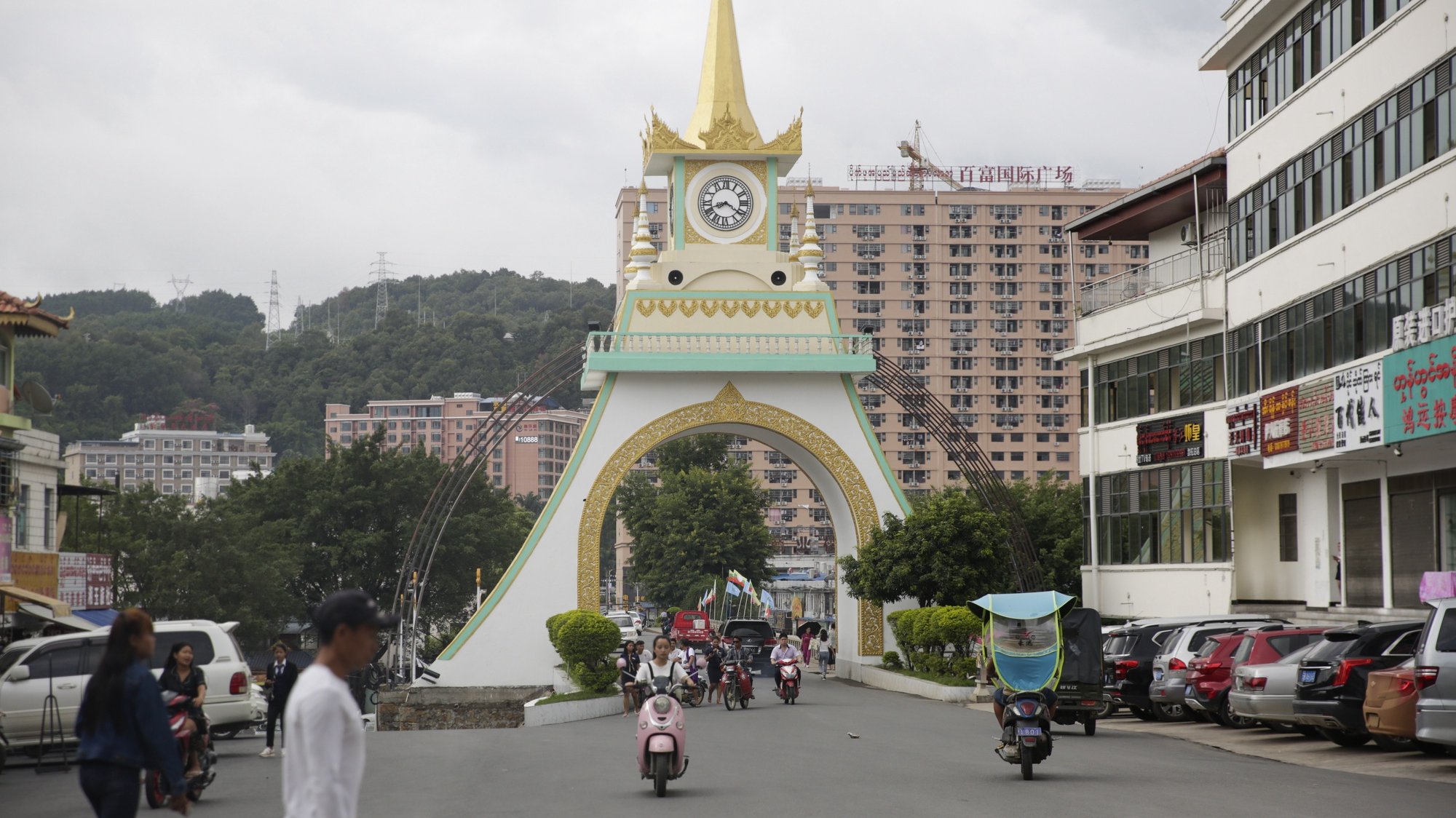 Peões e motociclitas no centro da cidade de Mong La, este de Shan Sate, Myanmar, 27 de junho de 2019