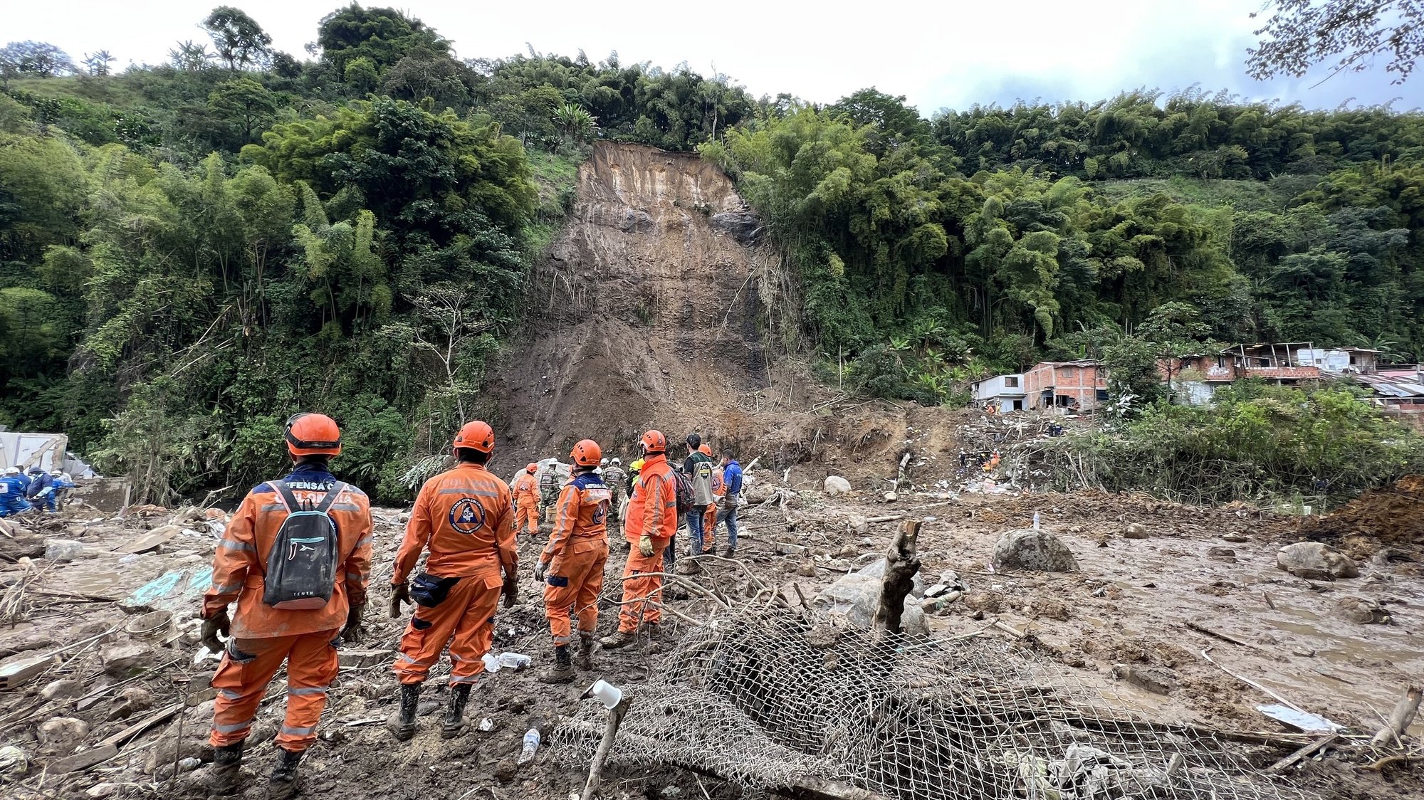 epa09739630 Lifeguards look for victims of a mudslide caused by heavy rains in Pereira, Colombia, 08 February 2022. At least 14 people, three of them thought to be young boys, have been killed and 35 were injured.  EPA/Santiago Gaviria