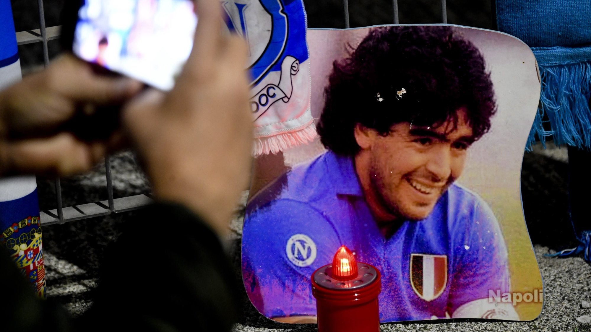 epa08842904 Napoli soccer supporters at the San Paolo stadium pay tribute to soccer legend Maradona in Naples, Italy, 25 November 2020 (issued on 26 November). Diego Maradona died on 25 November after a heart attack  EPA/CIRO FUSCO