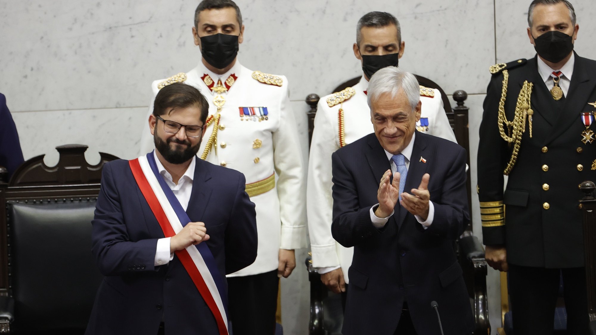 epa09817630 New Chilean President Gabriel Boric greets those attending the National Congress after receiving the presidential sash, while now former President Sebastian Pinera (R) applauds, during a investiture ceremony in Valparaiso, Chile, 11 March 2022. Boric, who assumes as the youngest president in the history of Chile, is sworn in on 11 March in the midst of the social challenges left by the social outbreak in the country, with a cabinet that for the first time will be majority women and before the hope and uncertainty involved in drafting a new constitution.  EPA/Alberto Valdes