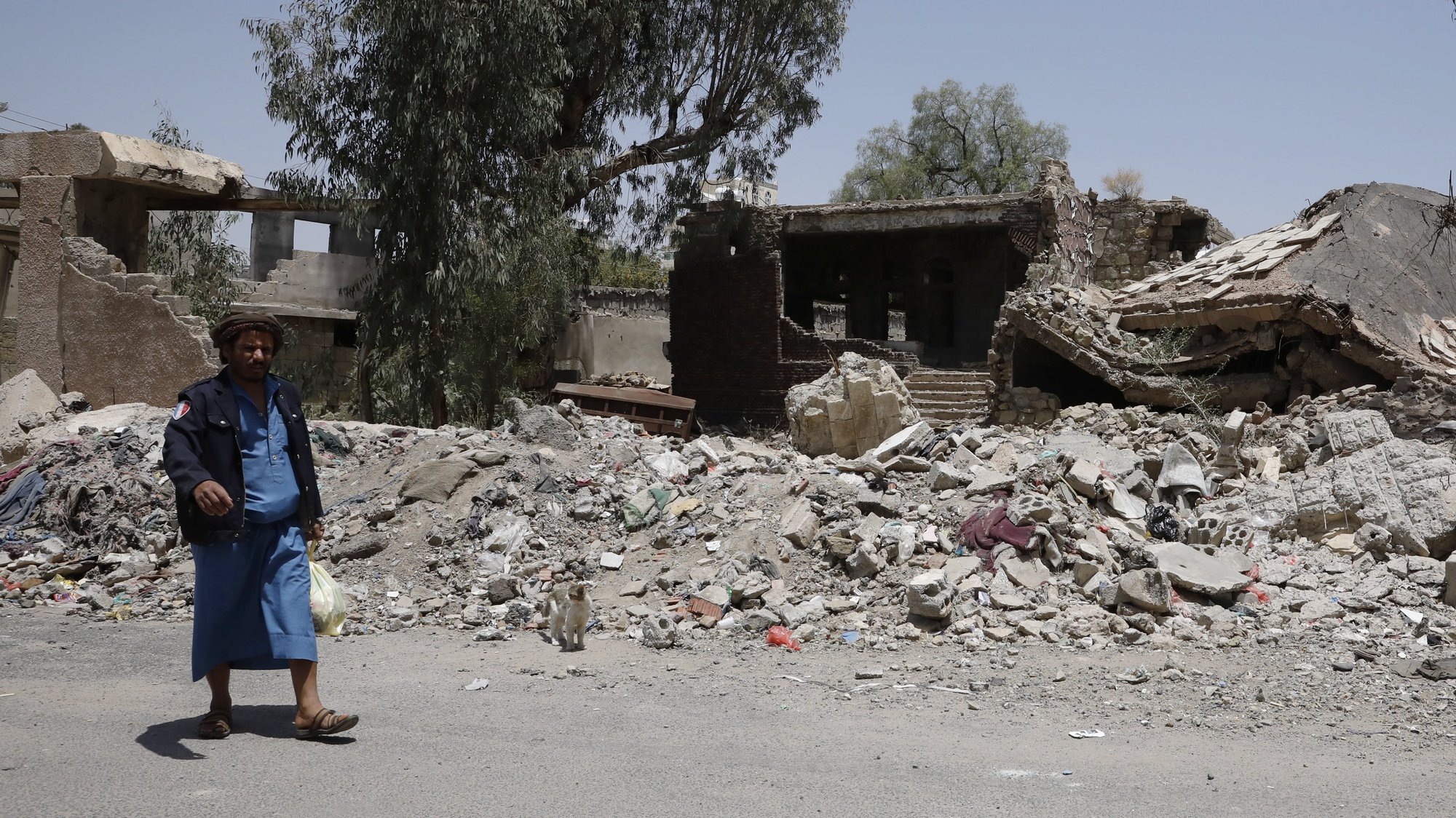 epa09860535 A Yemeni walks past a destroyed building targeted by previous Saudi-led airstrikes at a neighborhood in Sana&#039;a, Yemen, 30 March 2022. Intra-Yemeni consultations on the country’s devastating war started in Saudi Arabia amid the Houthis&#039; boycott, a few hours after the Saudi-led military coalition began a unilateral ceasefire in Yemen for the Muslim holy month of Ramadan. The consultations aim at discussing a peaceful settlement of the prolonged war in the Arab country. The Houthis have declined to attend the Saudi-hosted peace consultations being held from 30 March until 07 April 2022, claiming that Saudi Arabia is not a neutral country as it has been leading a military coalition fighting them since March 2015 for restoring the internationally-recognised Yemeni government.  EPA/YAHYA ARHAB