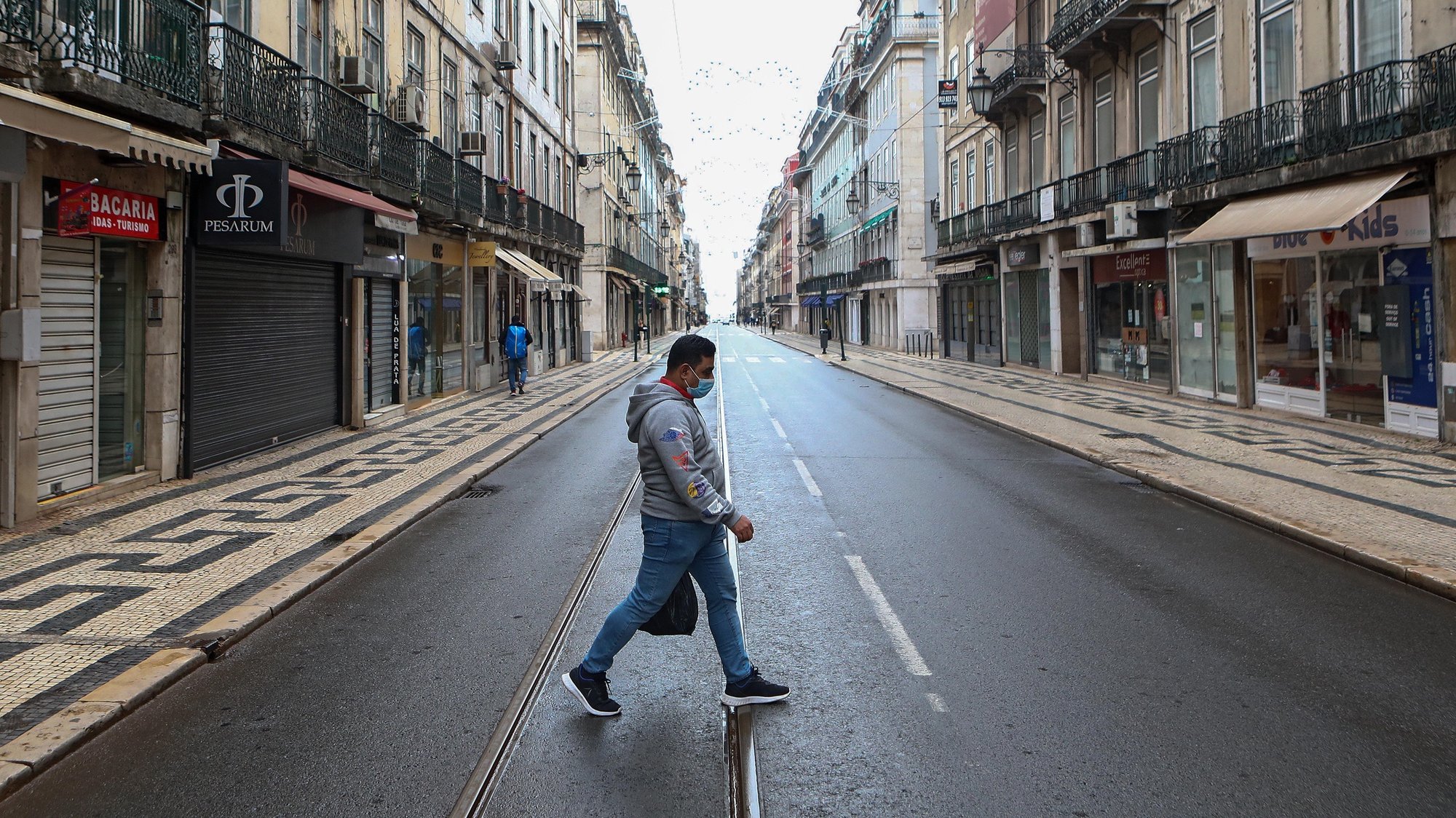 Um homem circula numa rua da Baixa de Lisboa