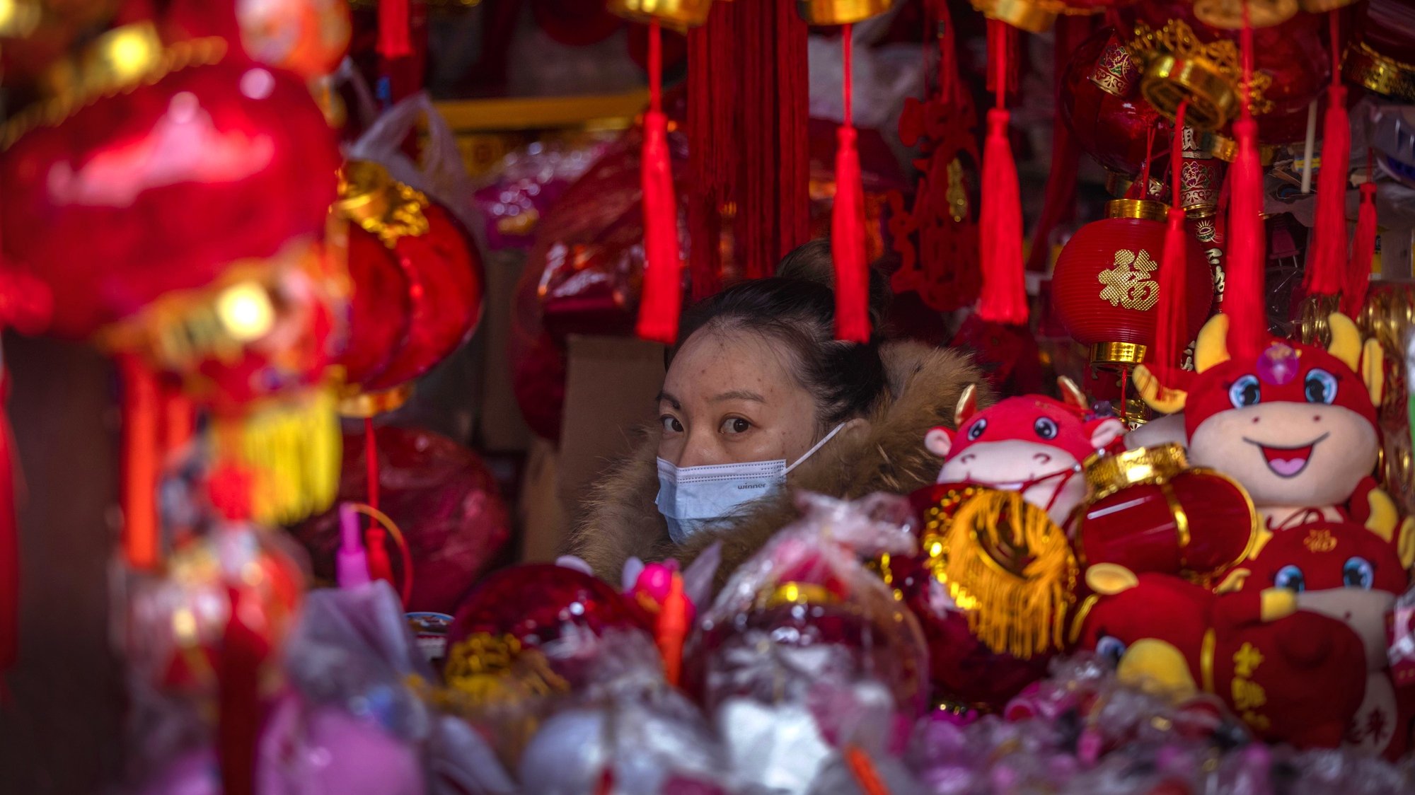 epa09014013 A woman offers lanterns and other Spring Festival decorations for sale in Shanghai, China, 15 February 2021. Tourist attractions, sports venues, movies, and other attractions in Shanghai are flooded with people who could not go back home to celebrate the Spring Festival due to the new outbreak of COVID-19 in China, government regulations, and travel restrictions. Usually Spring Festival lasts 16 days, starting from Chinese New Yearâ€™s eve to the Lantern Festival, and this year it is from 11. February to 26. February.  EPA/ALEX PLAVEVSKI