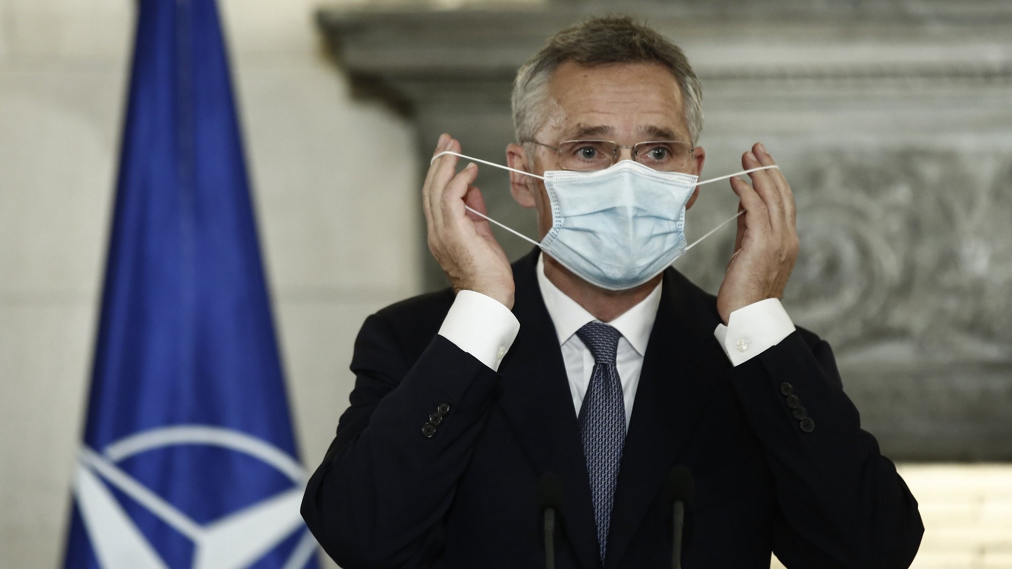 epa08723625 NATO Secretary General Jens Stoltenberg takes off his protective mask next to Greek Prime Minister Kyriakos Mitsotakis (not pictured ) during joint statements after his meeting in Athens, Greece, 06 October 2020. Greek Prime Minister Kyriakos Mitsotakis met NATO Secretary General Jens Stoltenberg in Athens, in the aftermath of a military de-confliction mechanism the alliance set up between Greece and Turkey.  EPA/YANNIS KOLESIDIS