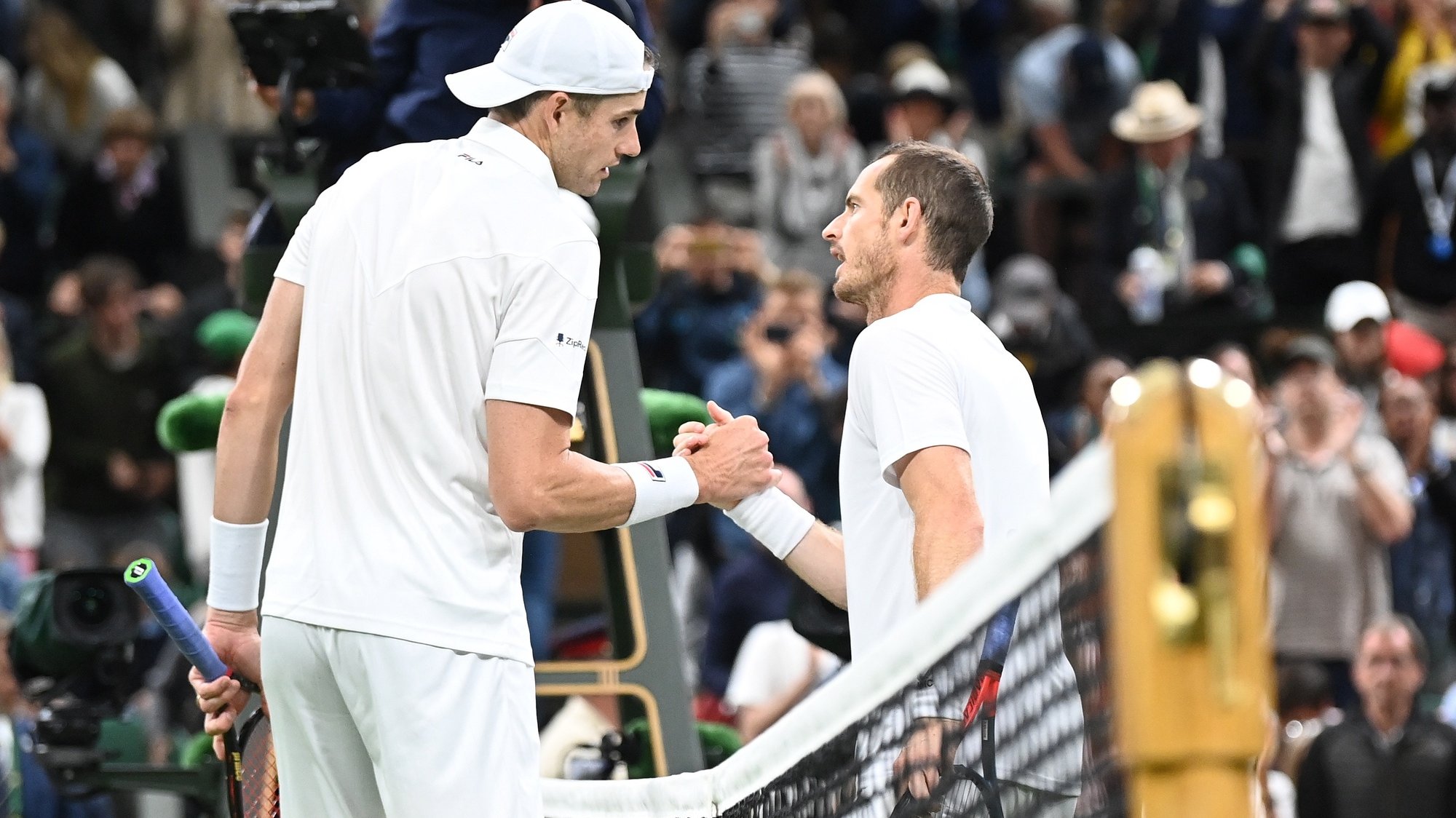 epa10042272 John Isner (L) of the US shakes hands at the net with Andy Murray of Great Britain after winning their men&#039;s second round match at the Wimbledon Championships, in Wimbledon, Britain, 29 June 2022.  EPA/NEIL HALL   EDITORIAL USE ONLY