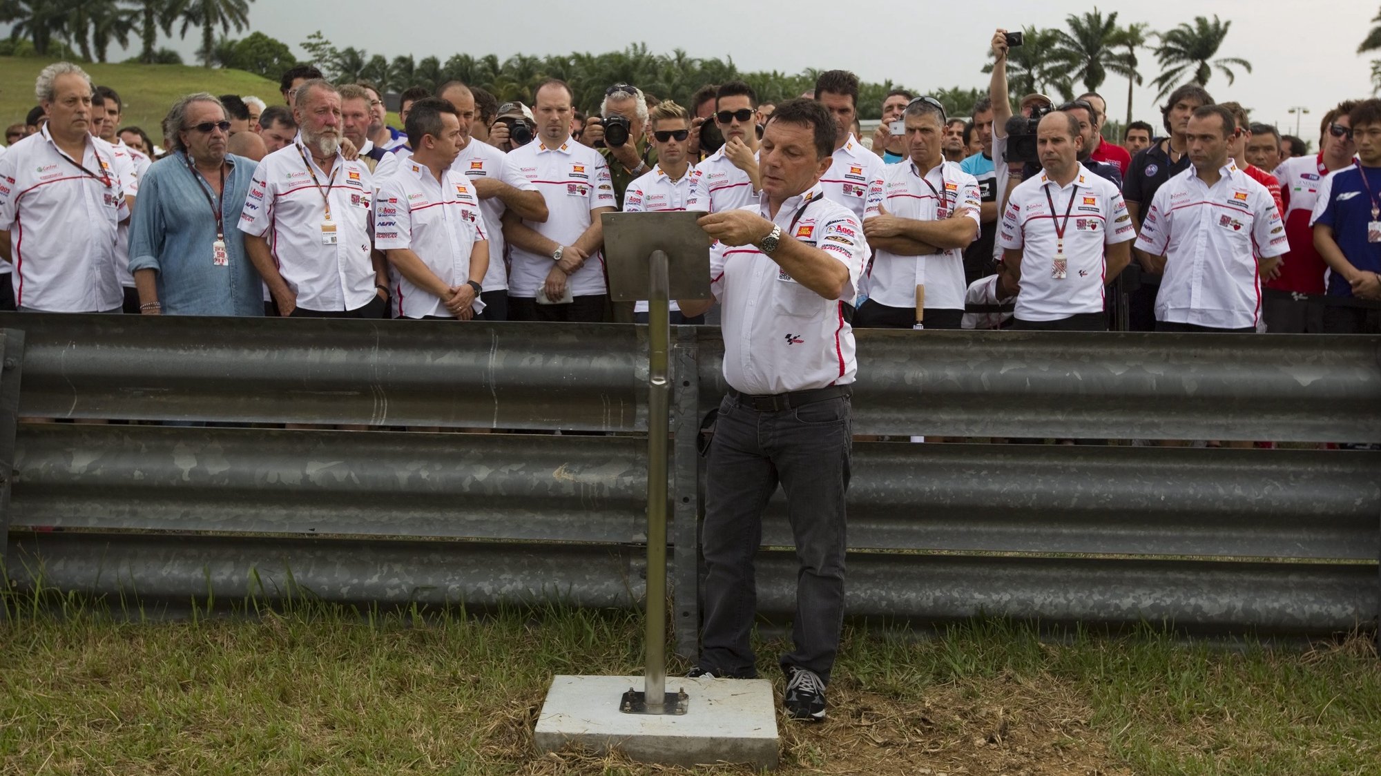epa03437133 MotoGP&#039;s San Carlo Honda Gresini team manager, Fausto Gresini (C) leads the installation of a plaque in memory of Italian rider Marco Simoncelli, who died in a crash in October 2011 during the Malaysian Grand Prix at Sepang International Circuit near  Kuala Lumpur, Malaysia 18 October 2012. The 2012  MotoGP World Championship will take place at Sepang International Circuit in Malaysia from 19 until 21 October 2012.  EPA/AHMAD YUSNI